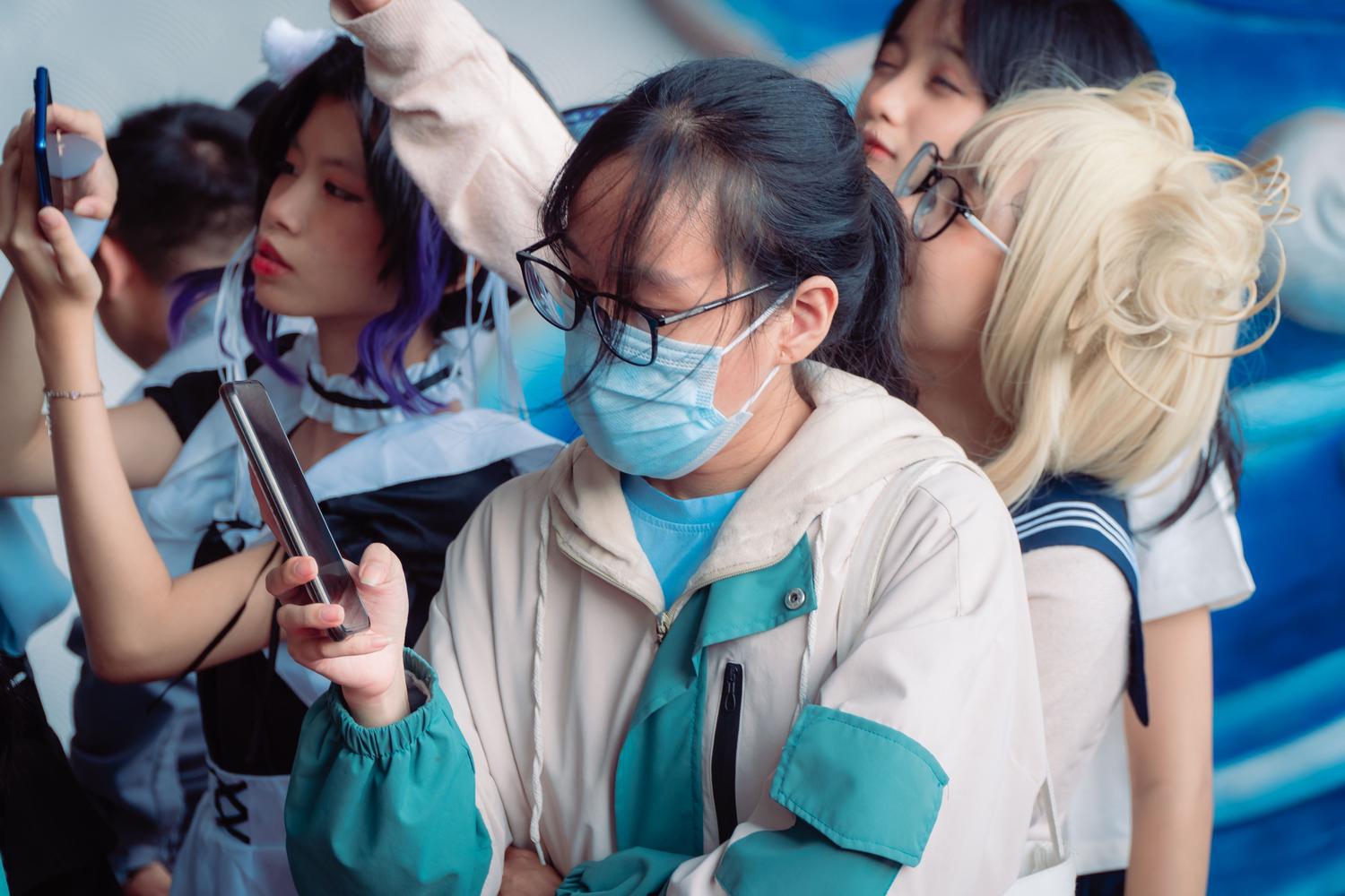 Cosplayers de anime utilizando sus smartphones para compartir su pasión en redes sociales