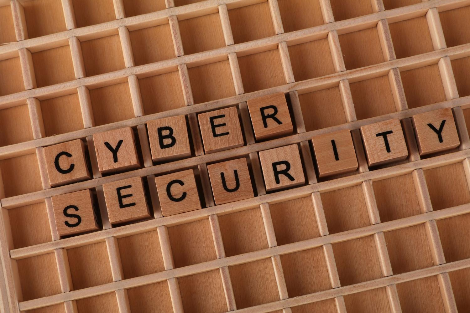 Bloques de madera formando las palabras Cyber Security sobre un fondo organizado, representando los fundamentos de la seguridad.