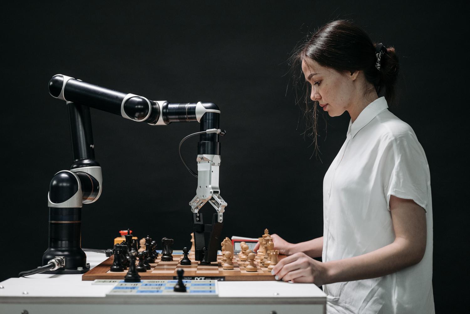 Una persona y un robot jugando al ajedrez, simbolizando la capacidad de razonamiento y la toma de decisiones estratégicas de los agentes de IA.