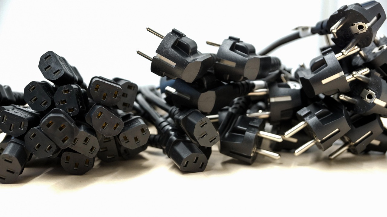 Enchufe eléctrico negro conectado a la corriente, perfecto para ilustrar el consumo fantasma y el modo standby.