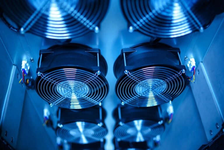 Primer plano de ventiladores de refrigeración en un centro de datos, representando el alto coste energético del enfriamiento de los servidores de IA.
