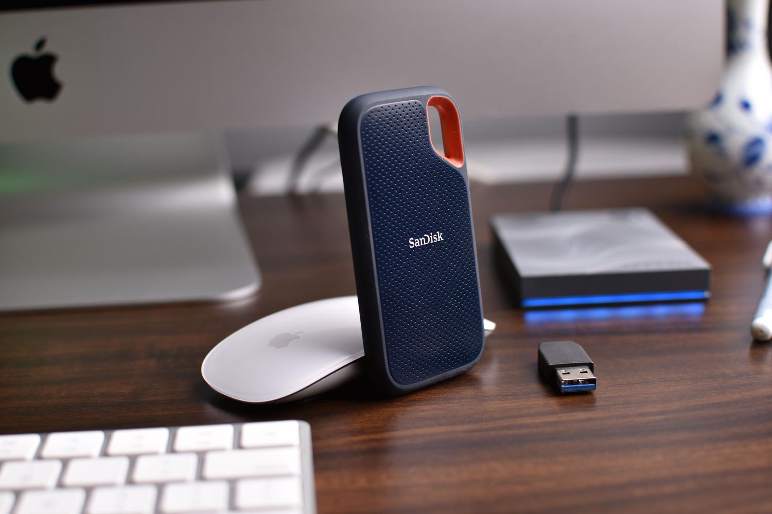 Detalle de un escritorio con discos duros externos, ratón y un USB, ideal para ilustrar el almacenamiento de datos.