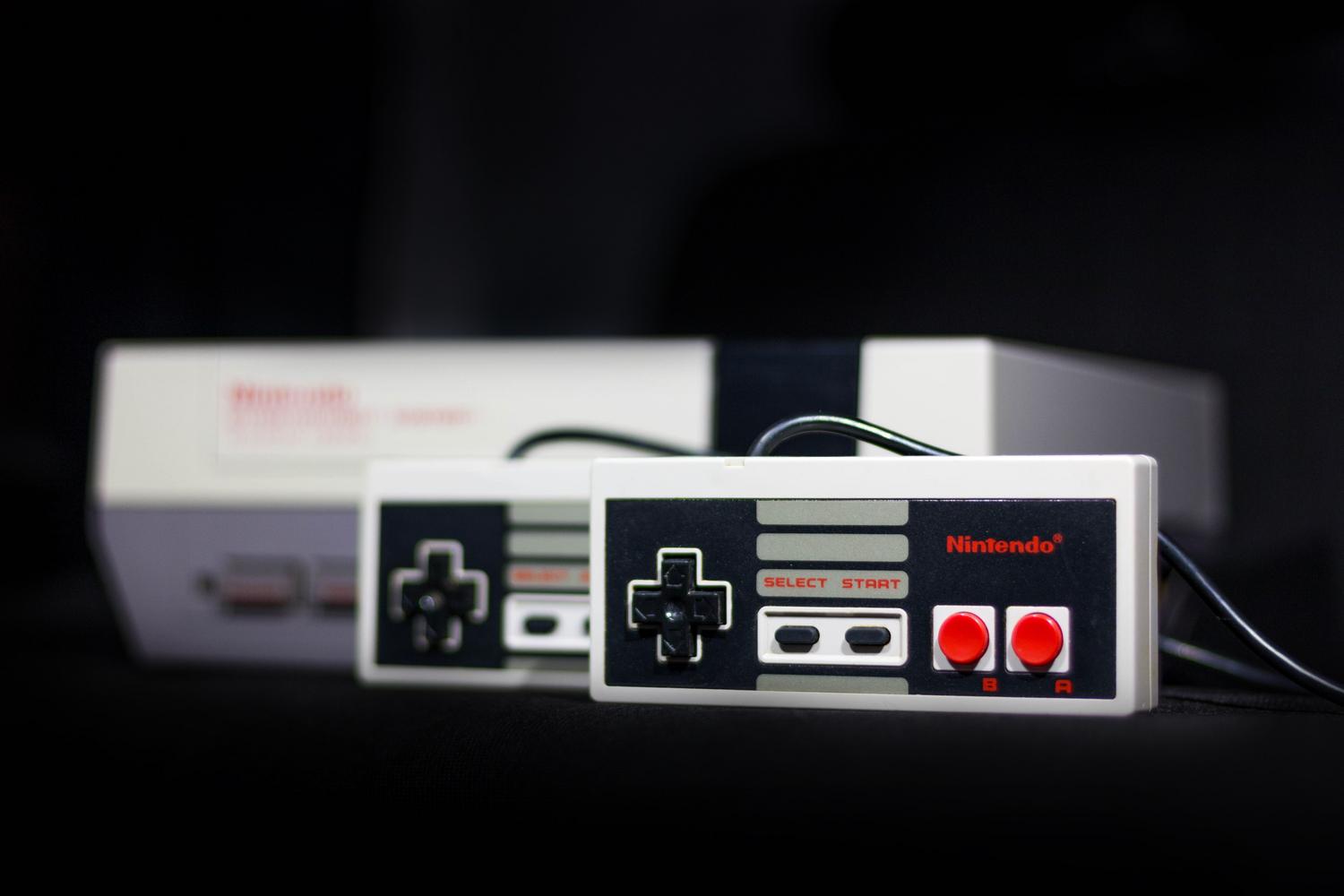 Consola Nintendo NES clásica con sus mandos, ejemplo icónico de hardware retro emulado.