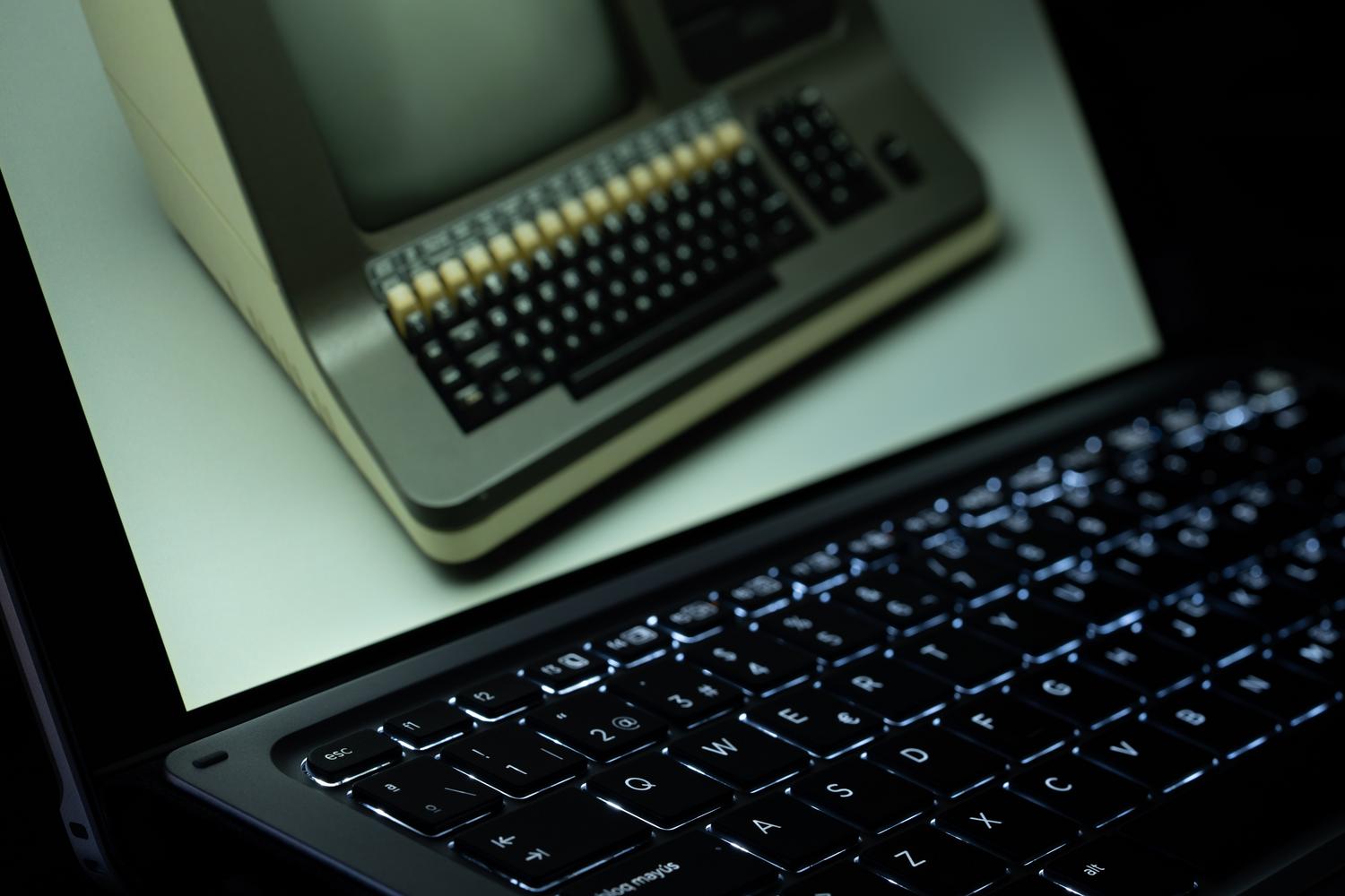 Reflejo de un ordenador vintage en la pantalla de un portátil moderno, simbolizando el concepto de emulación tecnológica. Reflejo de un ordenador vintage en la pantalla de un portátil moderno, simbolizando el concepto de emulación tecnológica.