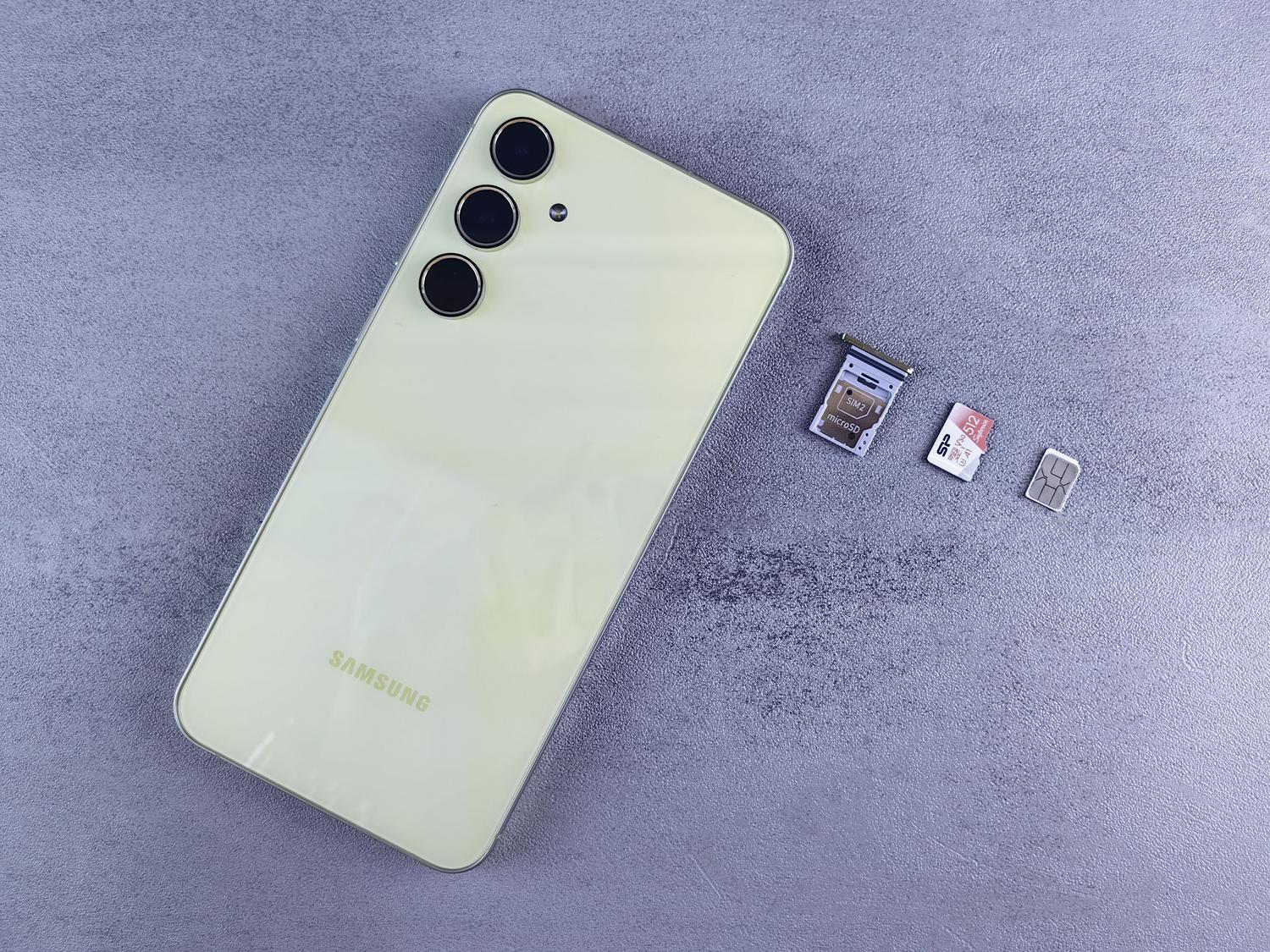 Inserción de una tarjeta microSD en un smartphone Android Smartphone con la bandeja de la SIM y una tarjeta microSD al lado, ilustrando el proceso de inserción de la memoria en el dispositivo.