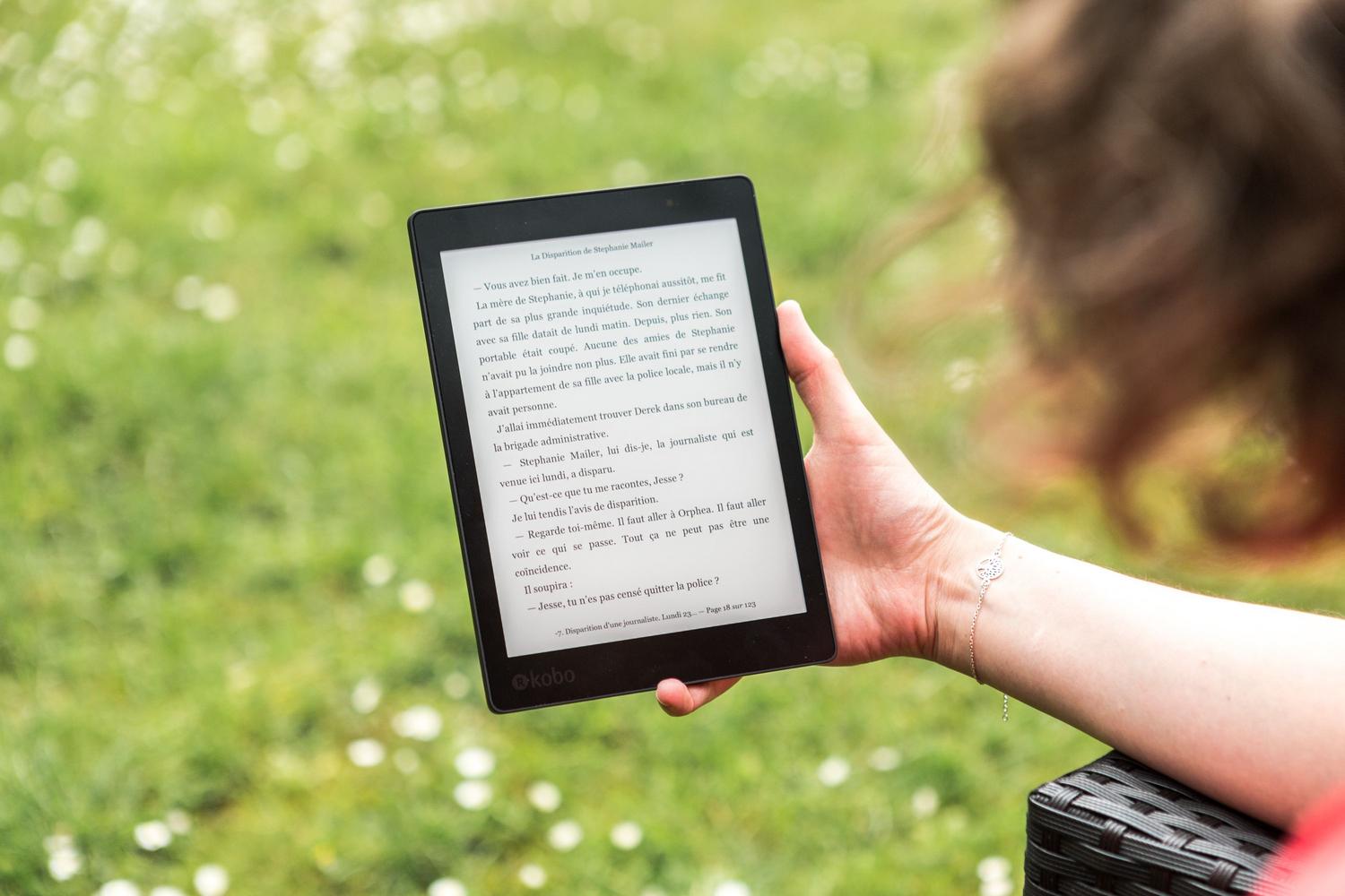 Persona leyendo en un dispositivo e-reader en un parque, representando la movilidad y el acceso remoto que ofrece el servidor de contenidos de Calibre.