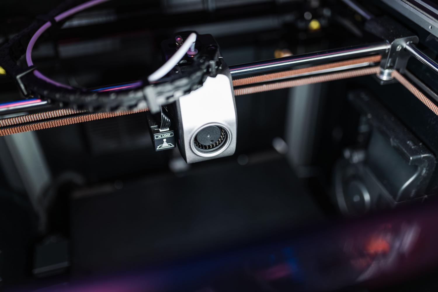 Detalle de los componentes electrónicos y sensores de alta tecnología de una impresora 3D profesional.