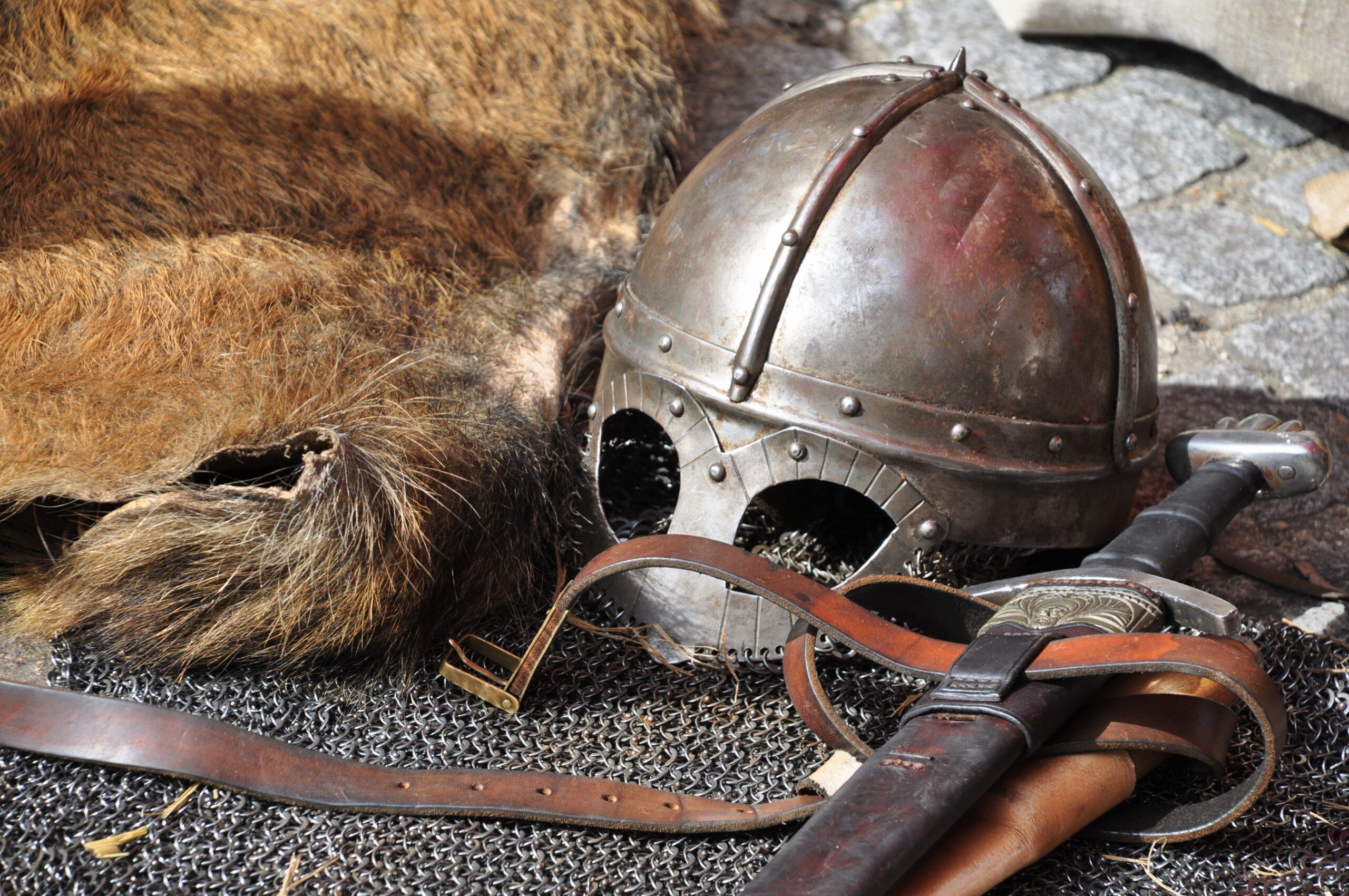 Primer plano de casco y espada medieval, ilustrando el sistema de triángulo de armas de la saga.
