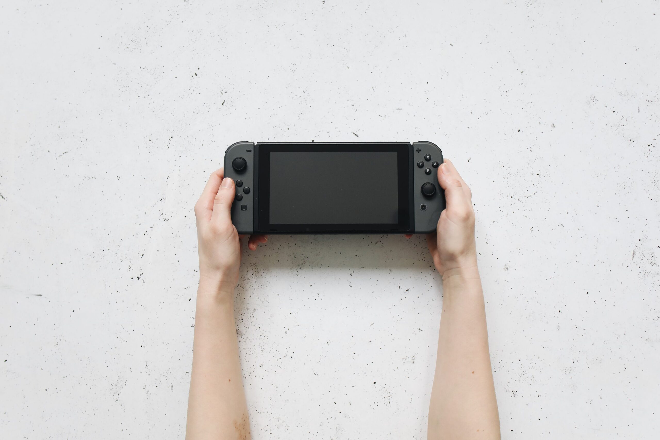 Persona jugando con una consola portátil, representando la accesibilidad de Fire Emblem en Nintendo Switch y móviles.