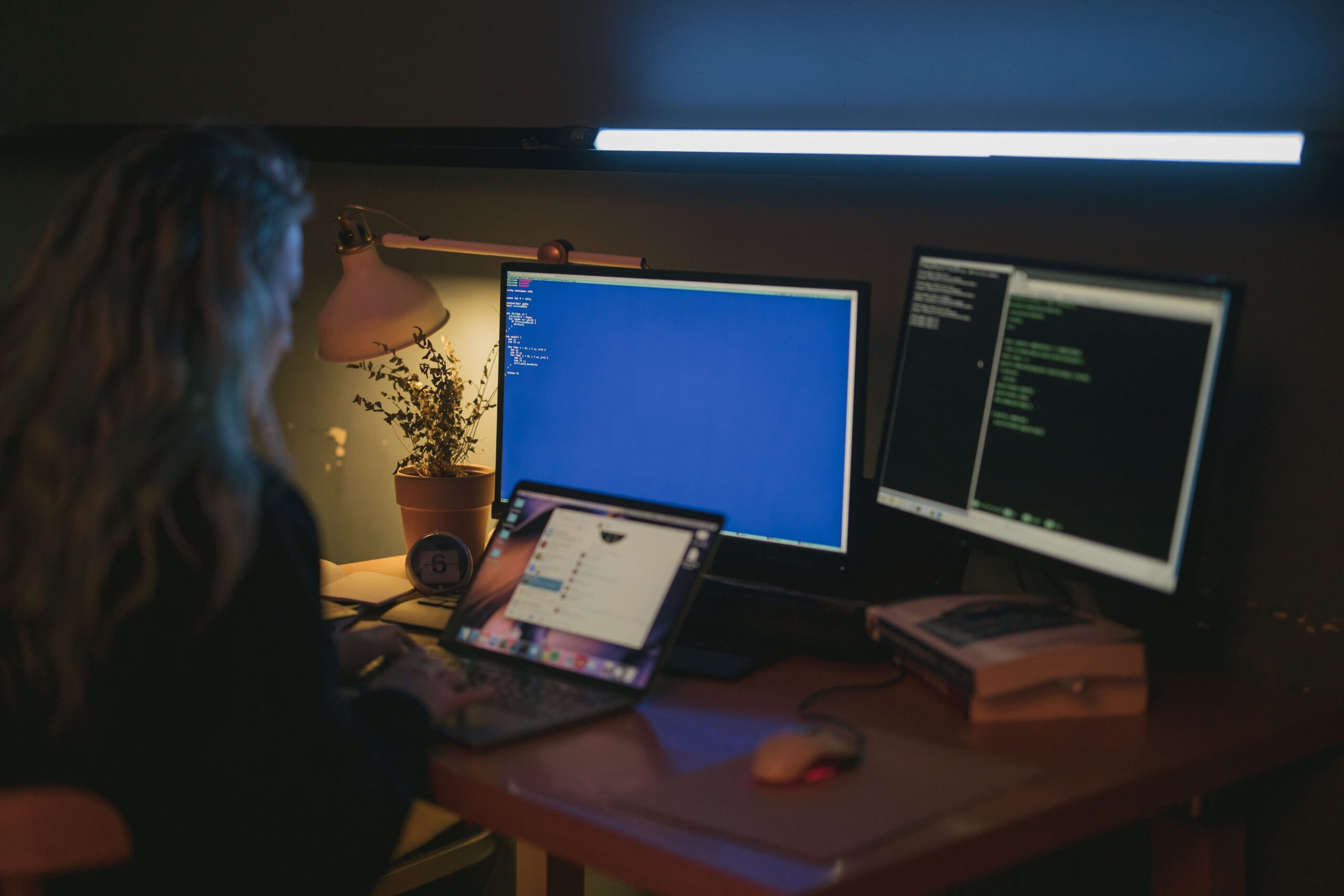 Profesional de ciberseguridad trabajando con múltiples monitores y terminales de código, ilustrando la configuración técnica de una VPN.
