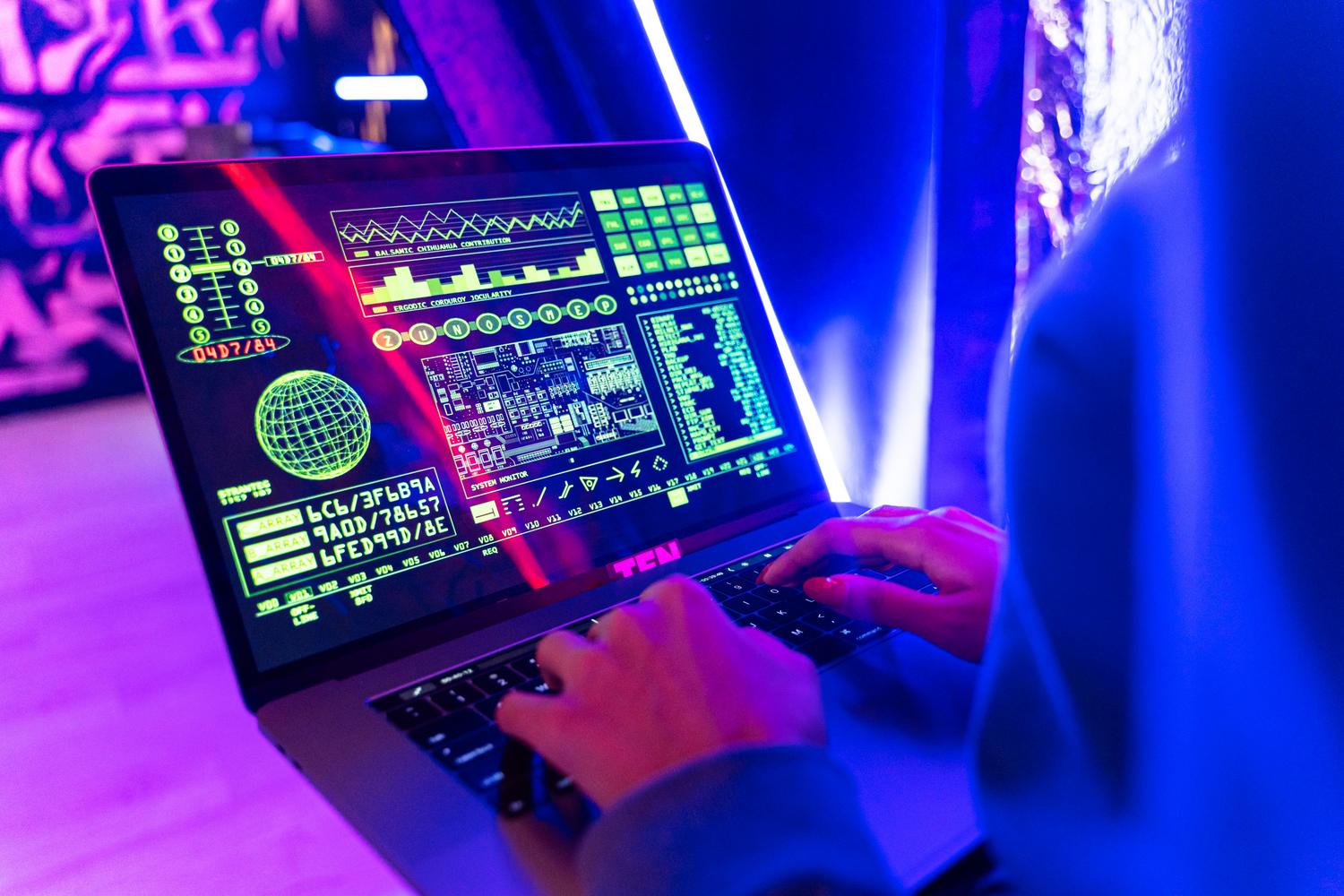 Manos de un experto interactuando con un panel de control avanzado de ciberseguridad, representando la gestión de la exposición y el monitoreo de red.