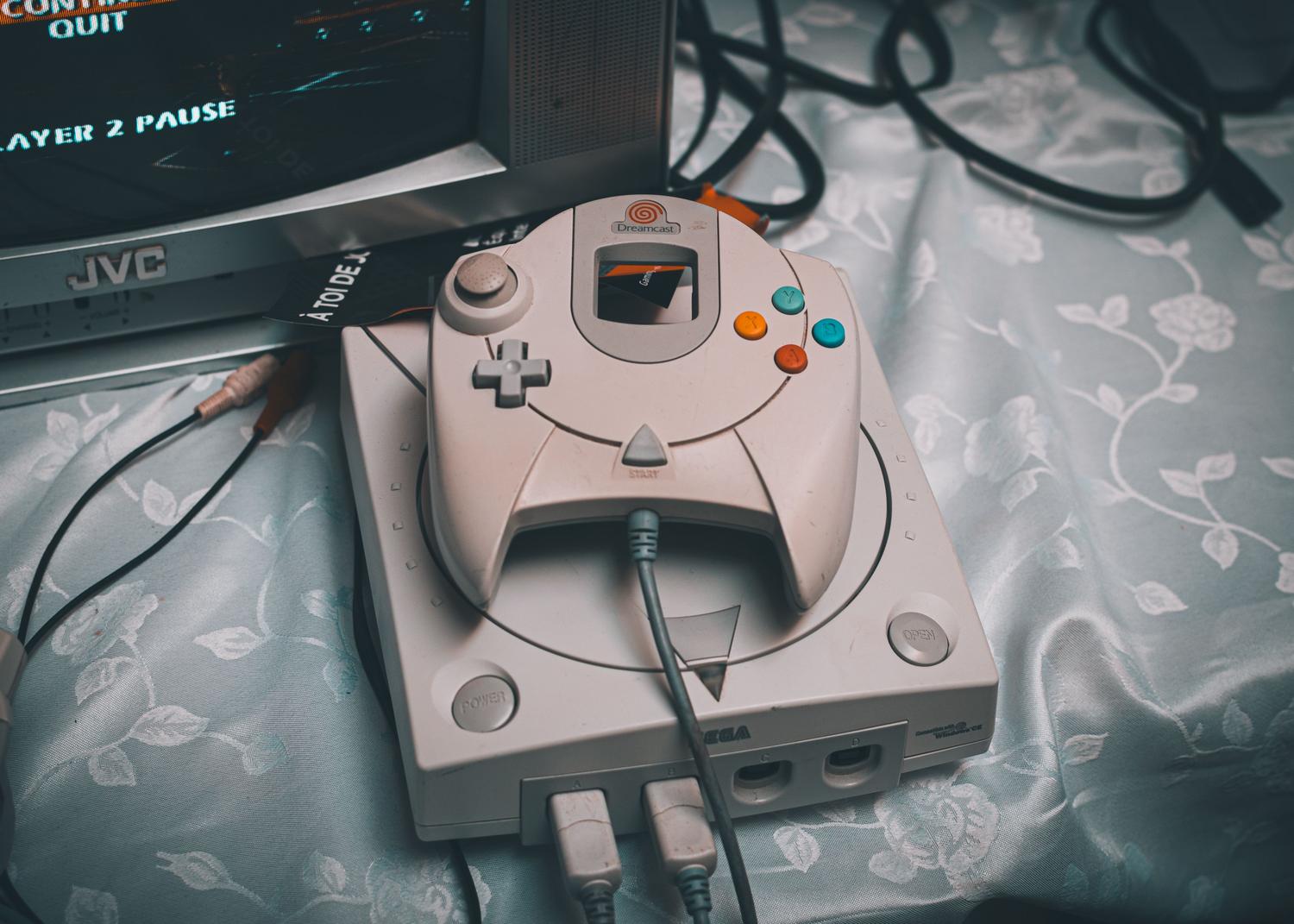 Consola Sega Dreamcast conectada a un monitor CRT antiguo, ilustrando el salto hacia los gráficos en 3D y la evolución tecnológica de los 90.