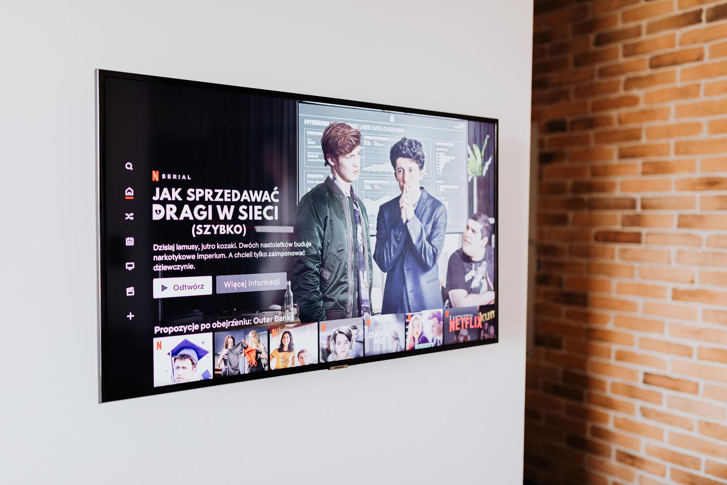 Smart TV en un salón moderno con diseño industrial, ideal para ilustrar el catálogo de series.
