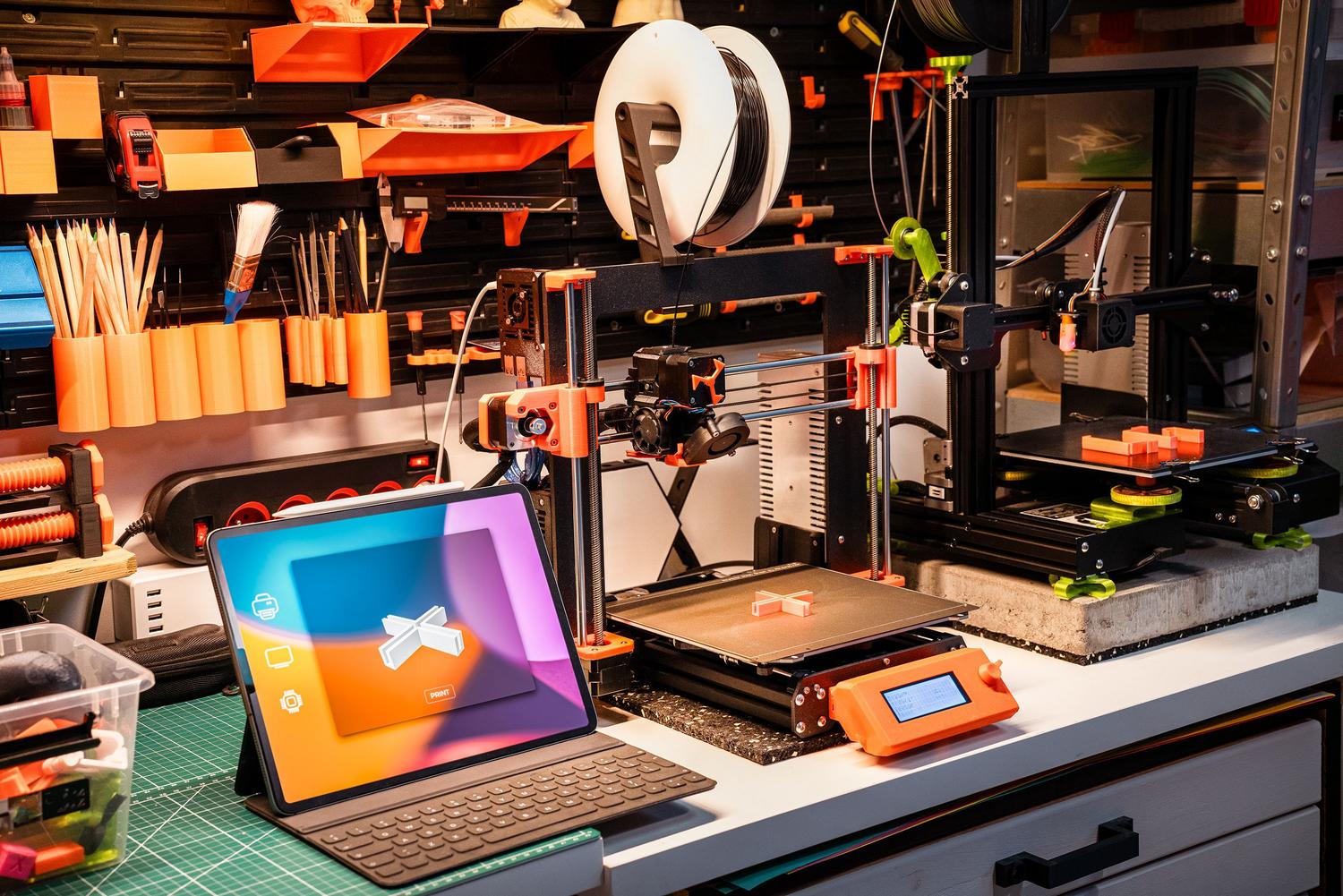 Taller de innovación tecnológica con impresoras 3D y dispositivos digitales, representando la consultoría y servicios profesionales.