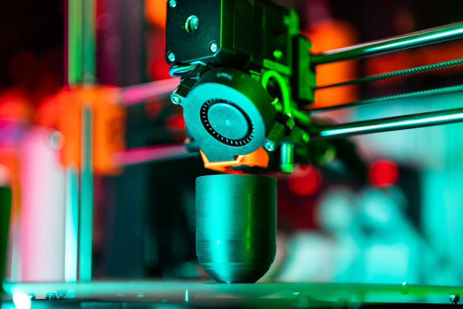 Proceso de impresión 3D moderno con iluminación vibrante, ideal para ilustrar la evolución tecnológica.