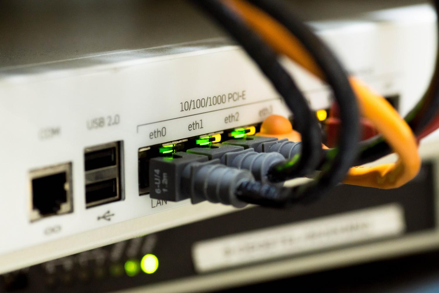 Primer plano técnico de cables Ethernet conectados a los puertos de un router para su configuración.