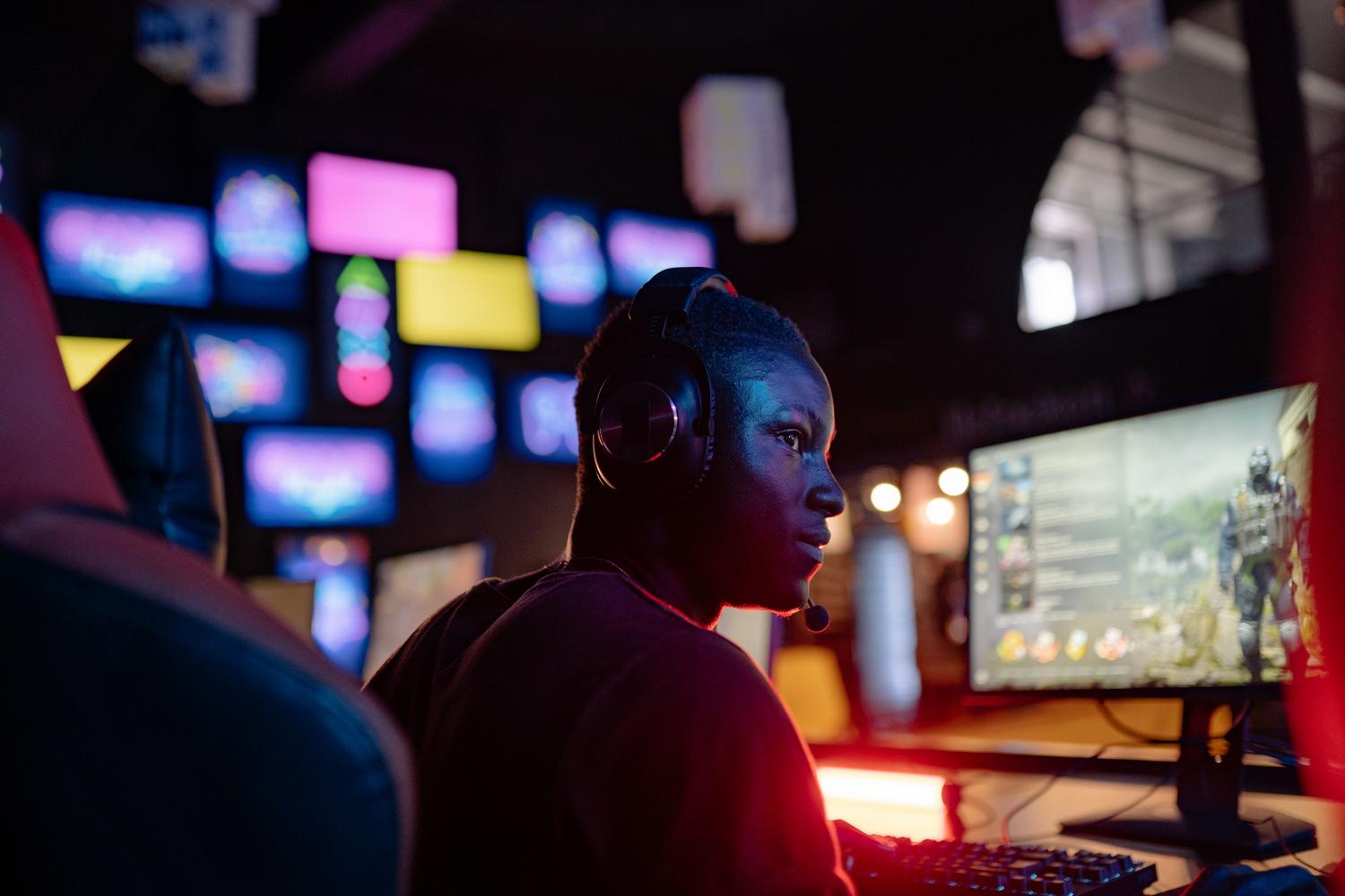 Gamer concentrado frente al monitor con iluminación LED, ilustrando la agilidad mental y el enfoque cognitivo de los deportes electrónicos.