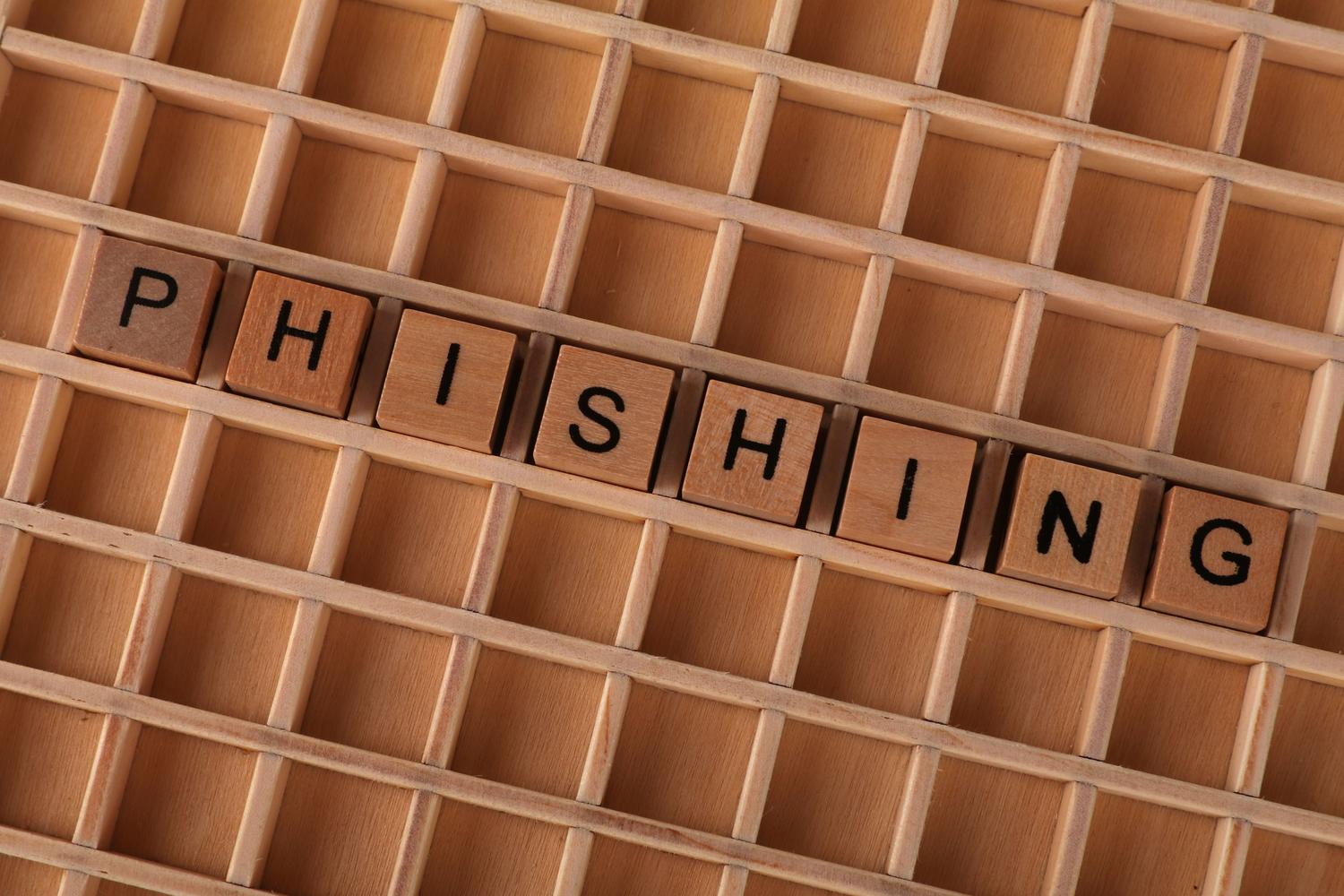 Concepto de Phishing representado con letras de madera sobre un fondo neutro