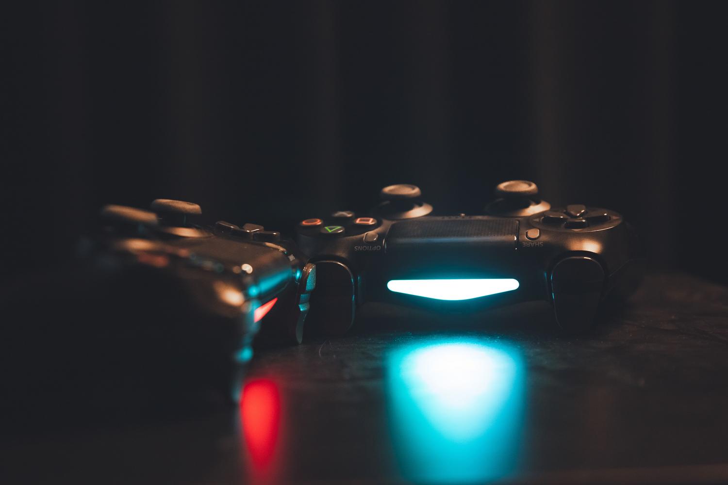 Mandos de juego iluminados sobre una superficie oscura, creando un ambiente gaming.