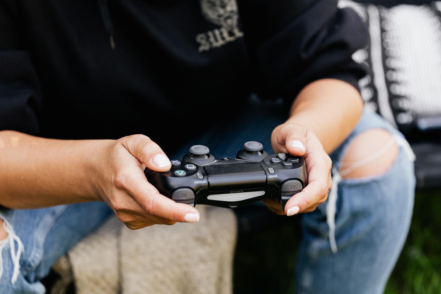 Primer plano de unas manos sosteniendo un mando de videojuegos mientras juega.