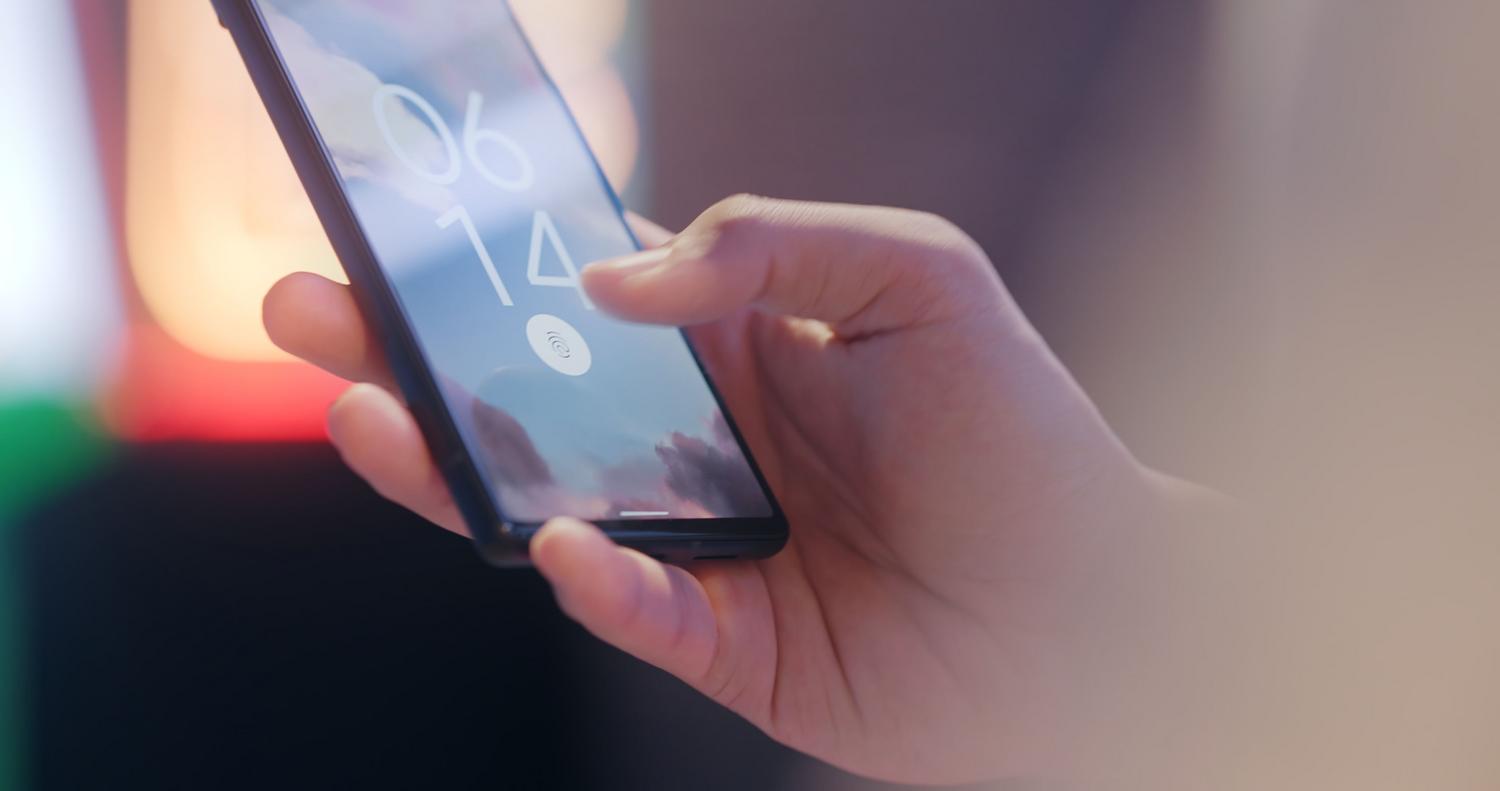 Uso del sensor de huellas dactilares en la pantalla de un móvil para el desbloqueo biométrico.