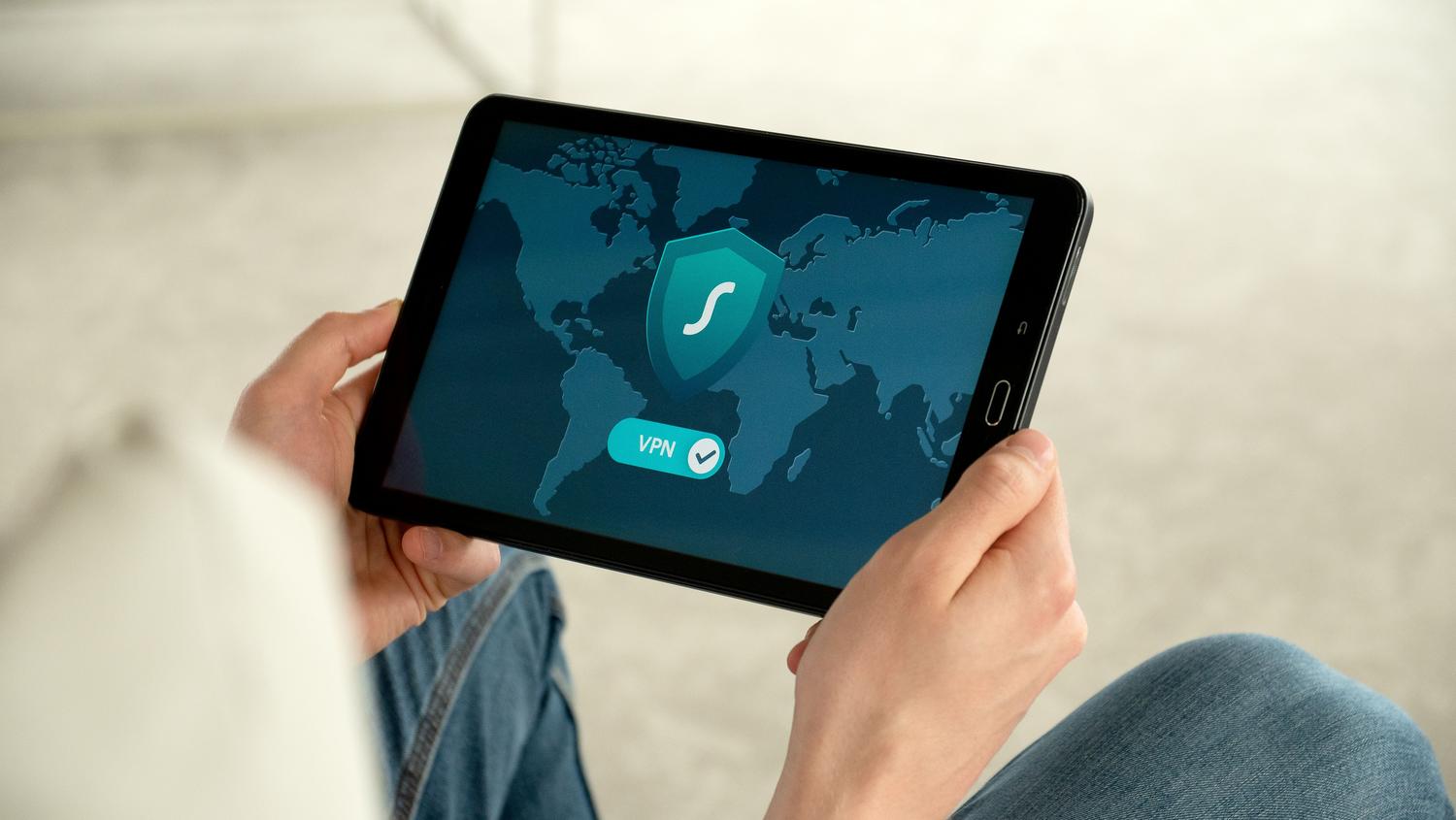 Persona utilizando una tablet con una conexión VPN activa para navegar de forma anónima y segura.