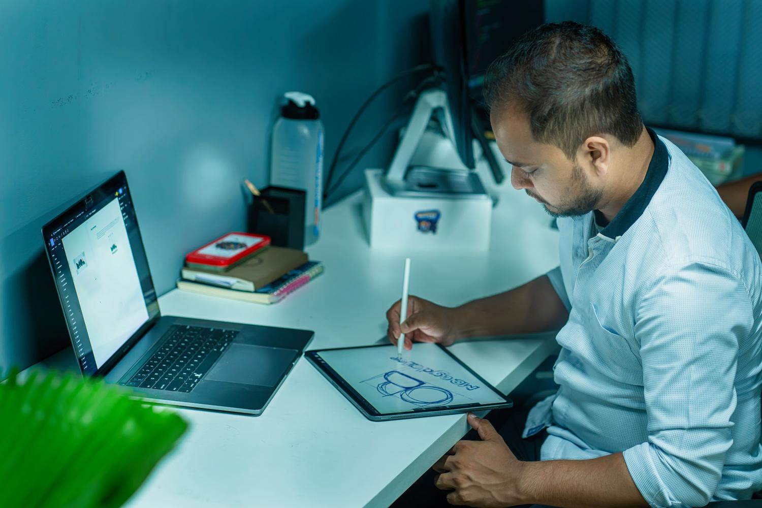 Diseñador UX/UI trabajando con una tableta gráfica en una oficina moderna, representando la creación de interfaces intuitivas e inclusivas