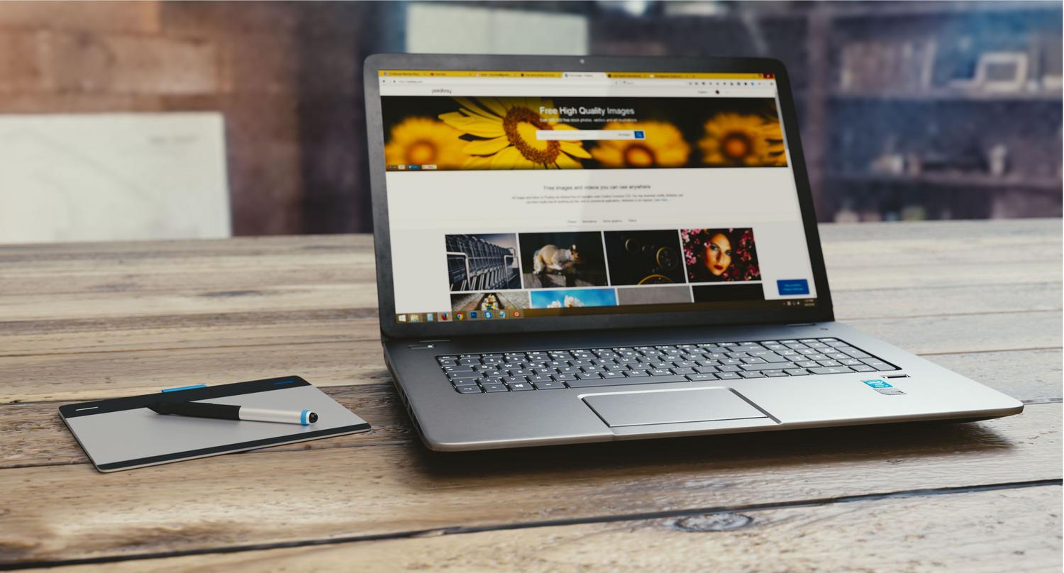 Espacio de trabajo digital con portátil y tableta, representando la creación de contenidos profesionales.