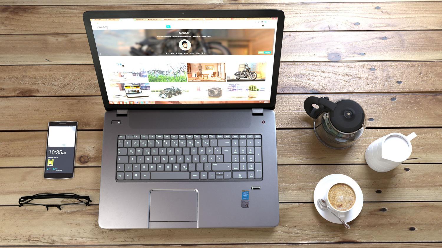 Vista cenital de un escritorio moderno con laptop y móvil, destacando el diseño responsivo de las webs.