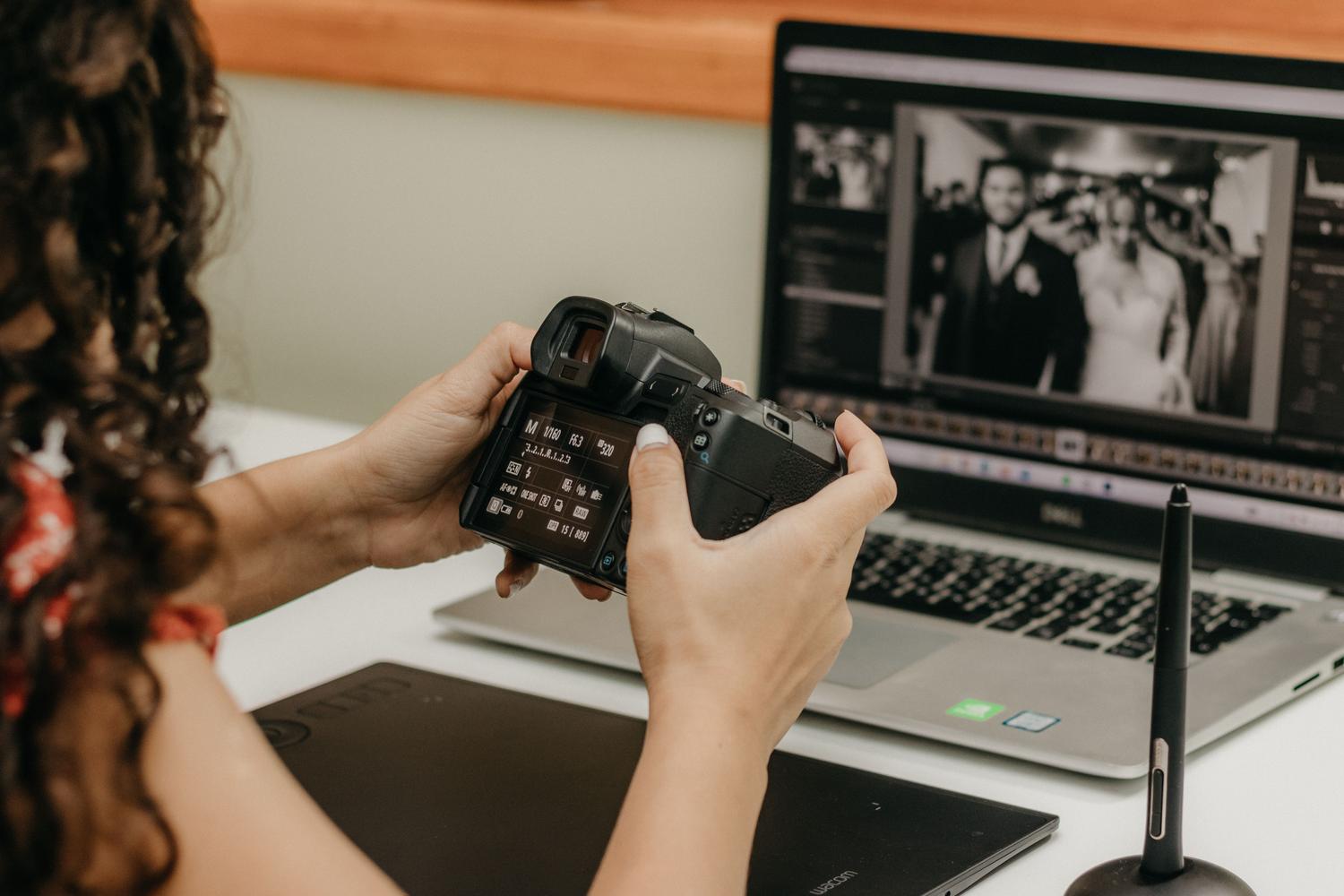 Fotógrafo profesional revisando ajustes de cámara mientras edita fotografías de boda en su ordenador.