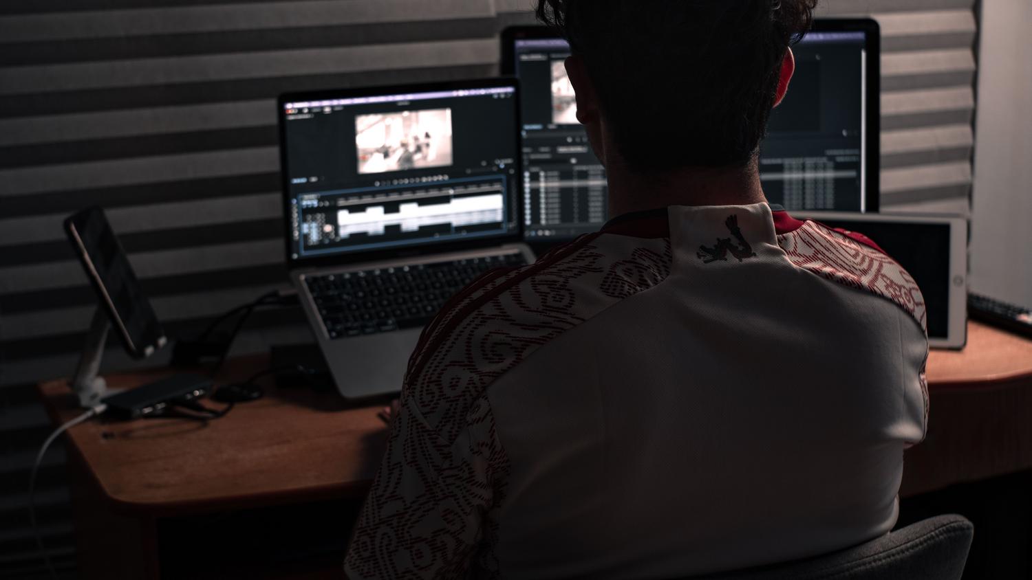 Editor de vídeo trabajando en un estudio profesional con múltiples monitores para optimizar el flujo de trabajo.
