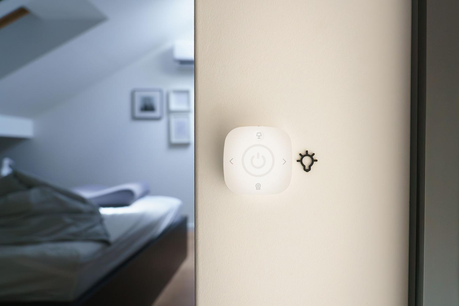 Detalle de un interruptor inteligente en un dormitorio moderno, mostrando su integración en el entorno doméstico.