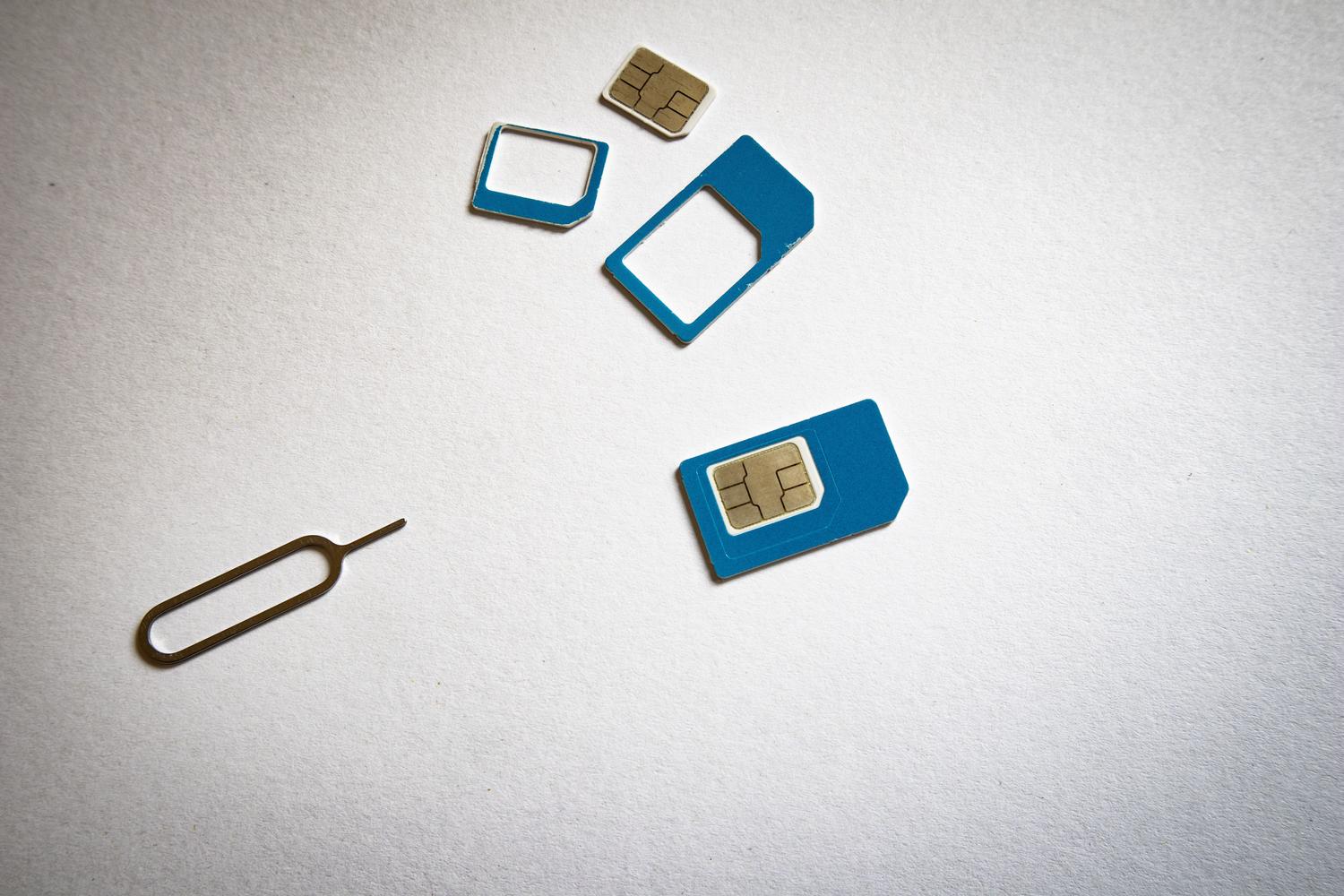 Primer plano de tarjetas SIM y herramienta de extracción para ilustrar el robo físico y el SIM Swapping