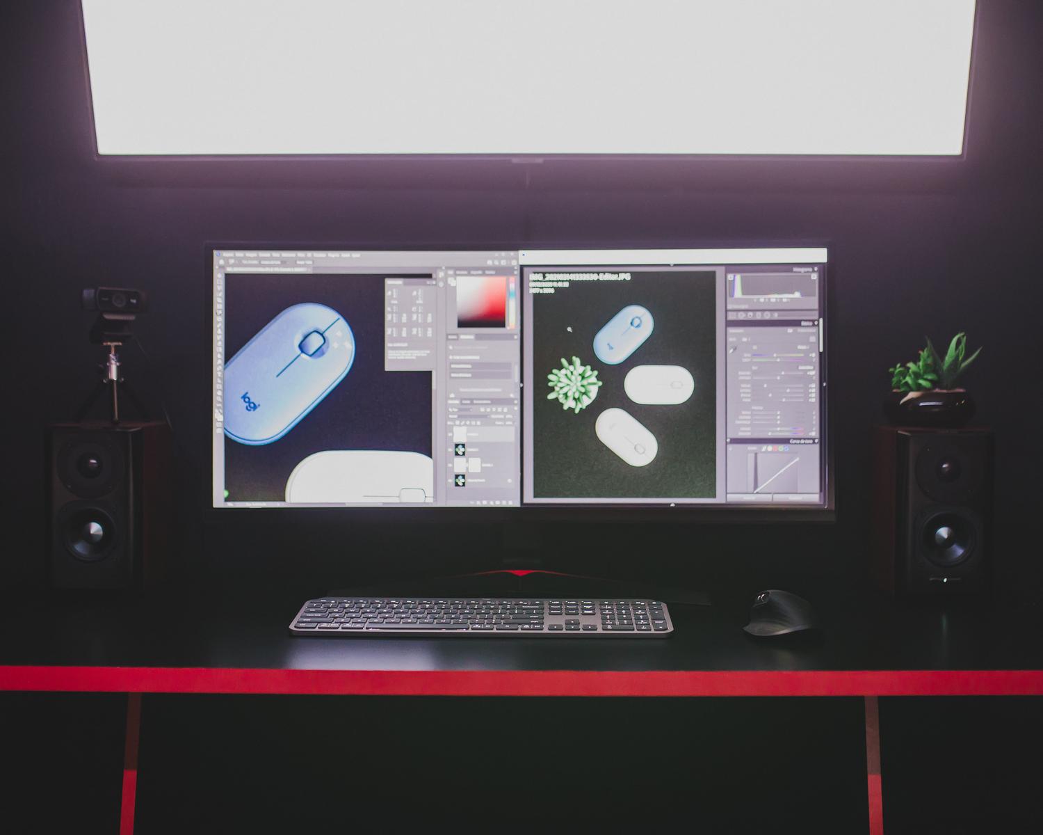 Configuración profesional de diseño gráfico con monitores duales y herramientas de edición, representando la precisión y calibración de color.
