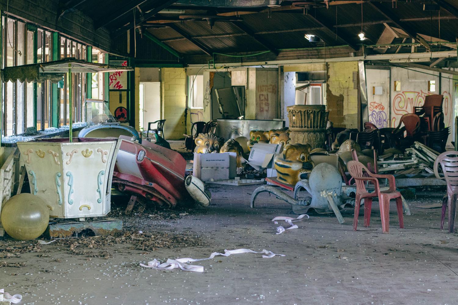 Un carrusel decadente y atracciones oxidadas en un parque de diversiones abandonado, capturando la esencia de la pesadilla.