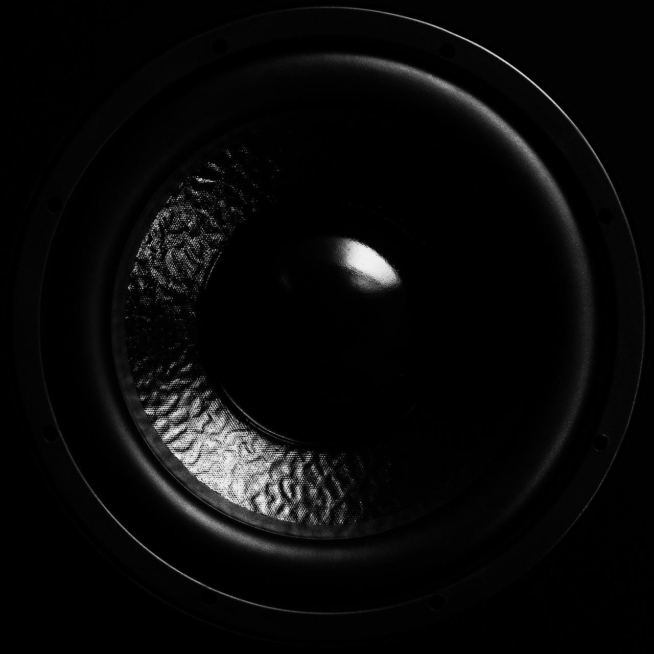 Primer plano artístico y monocromático de la membrana de un subwoofer, destacando la potencia y profundidad de los bajos. Primer plano artístico y monocromático de la membrana de un subwoofer, destacando la potencia y profundidad de los bajos.