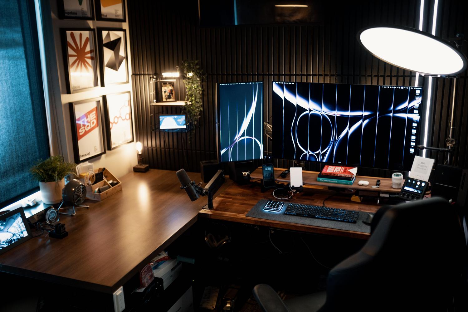 Escritorio moderno y minimalista con soporte para dos monitores, combinando una pantalla ultrawide y una vertical para máxima productividad.