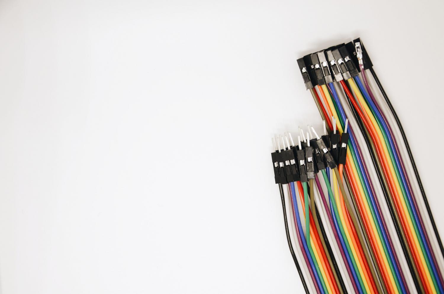 Cables puente (jumper wires) de colores, representando la simplicidad de la comunicación de dos hilos (SDA y SCL) del protocolo I2C.