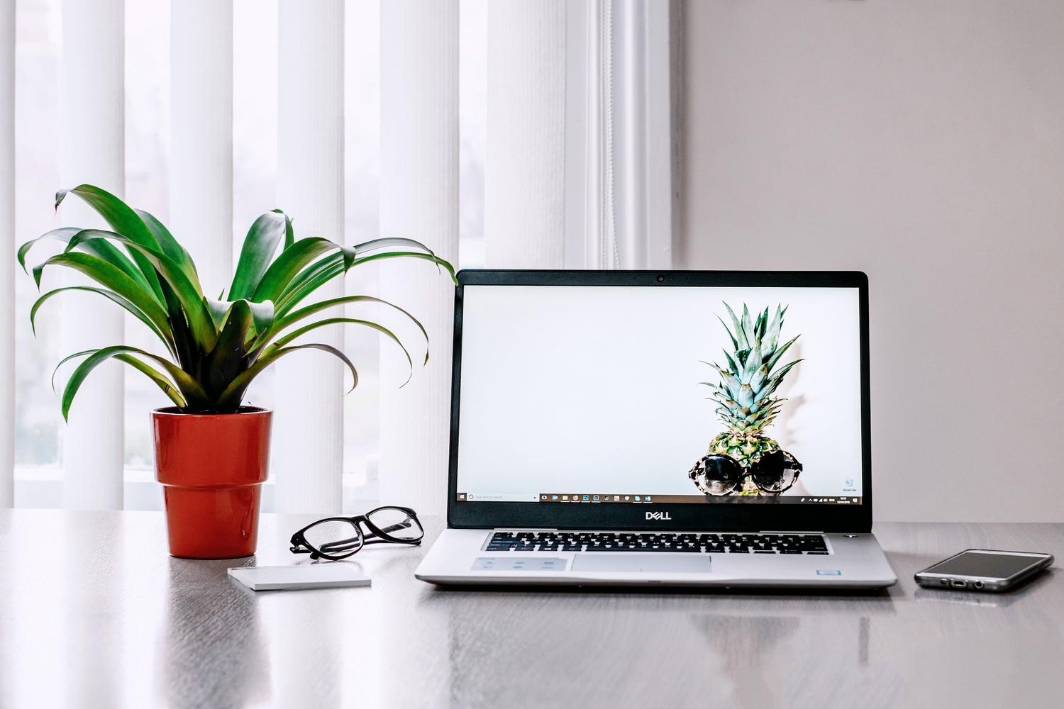 Espacio de trabajo tecnológico con portátil y smartphone, ideal para tareas de oficina y navegación web.