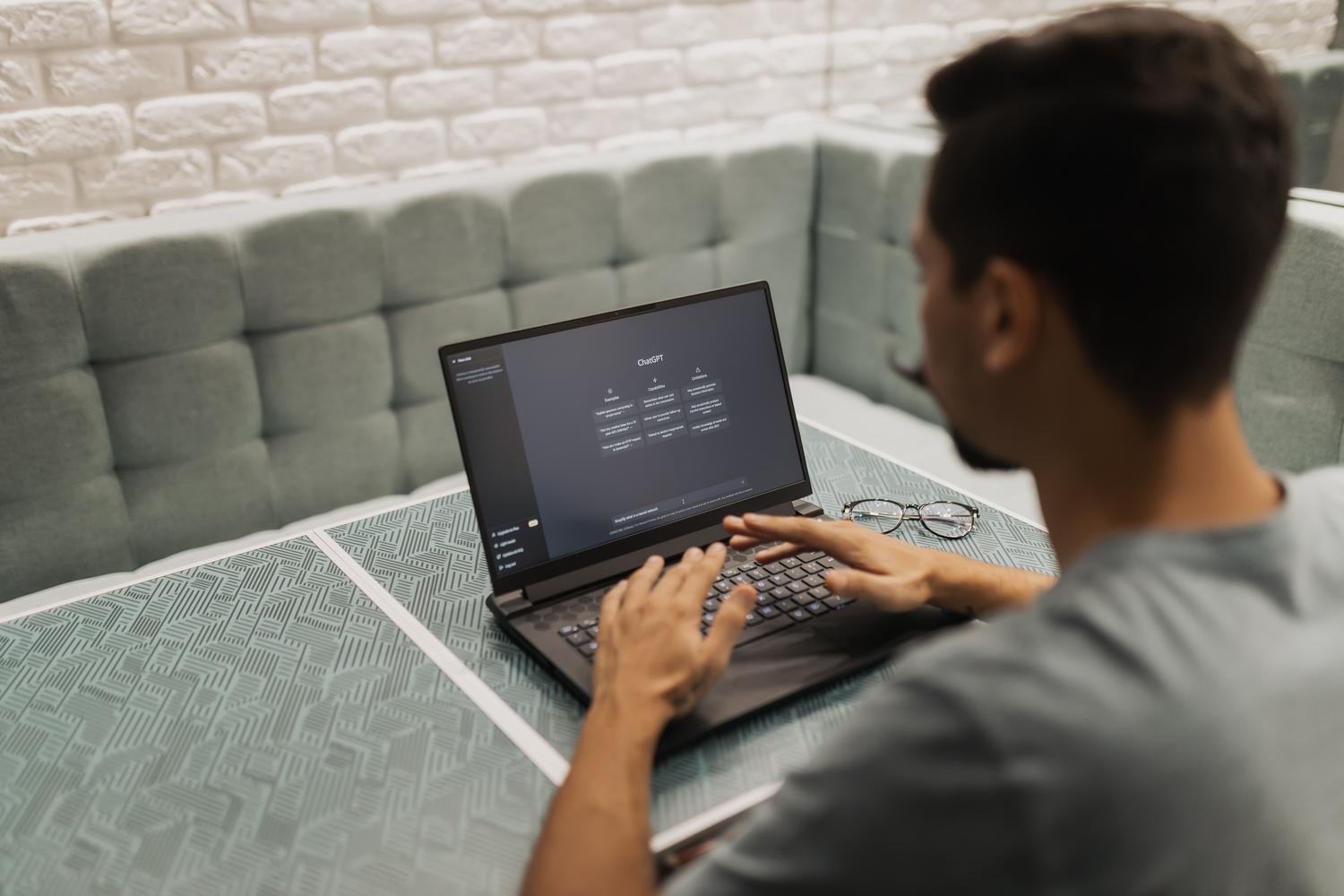 Profesional trabajando con una interfaz de IA en un espacio de coworking moderno, ilustrando la productividad impulsada por la IA.