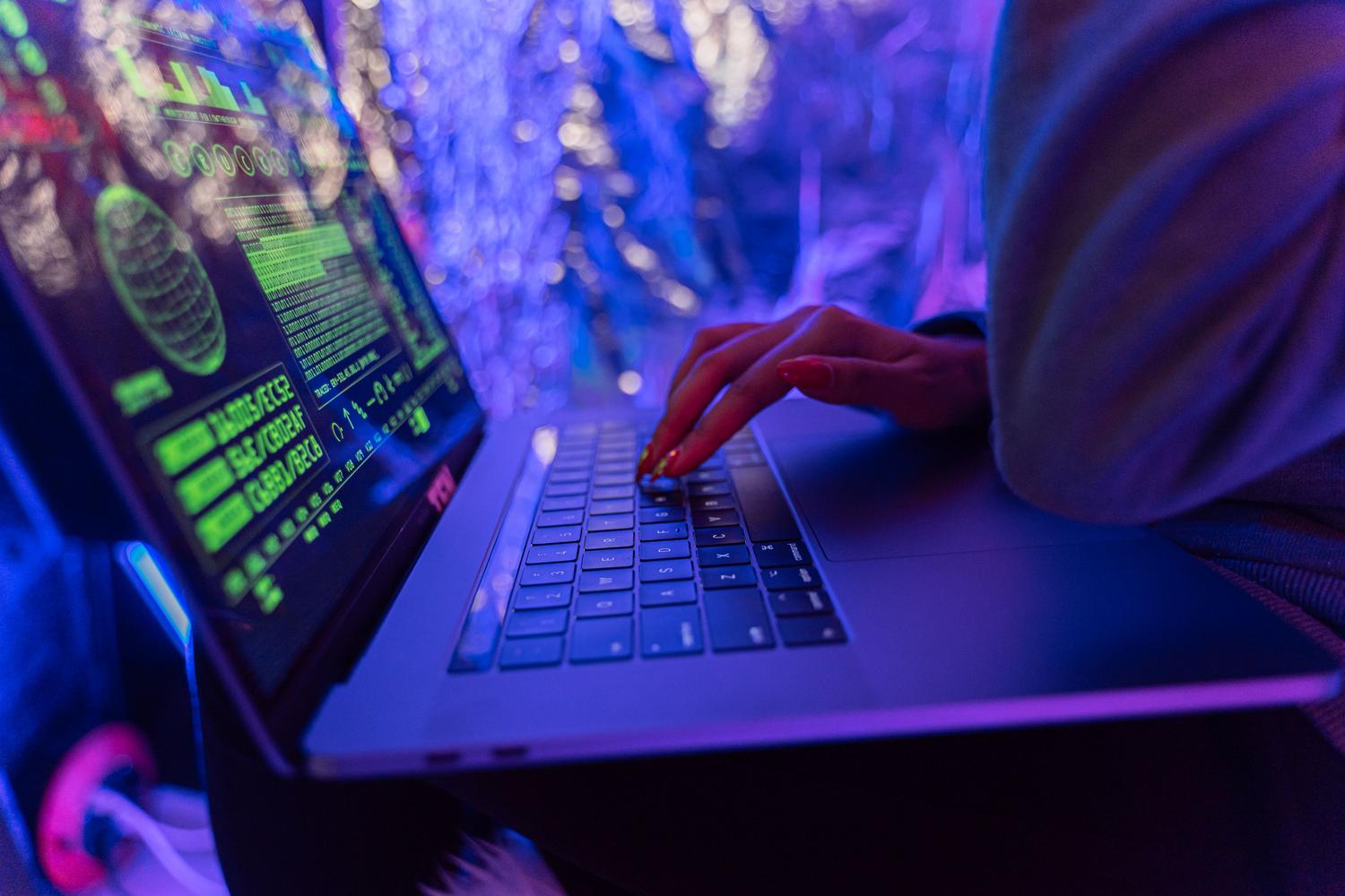 Primer plano de un teclado y pantalla con gráficos de ciberseguridad, ilustrando la importancia de la protección y la autenticación de dos pasos.