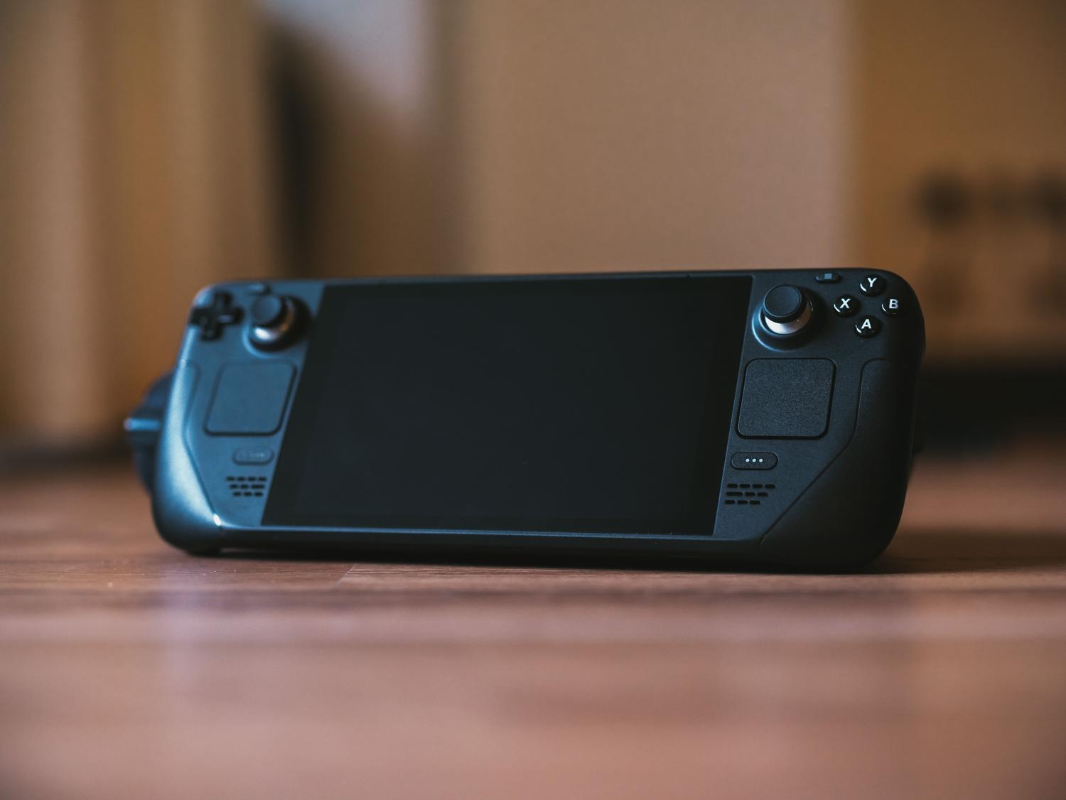 Consola portátil Steam Deck sobre una superficie de madera, ejemplificando la convergencia entre bibliotecas digitales y gaming portátil.