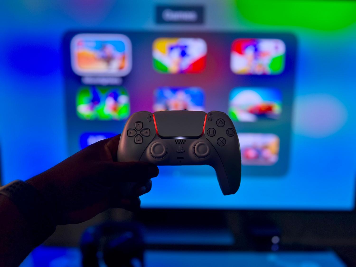 Mando de consola moderno frente a una pantalla digital vibrante que simula una biblioteca de juegos, simbolizando la inmediatez y el acceso digital.