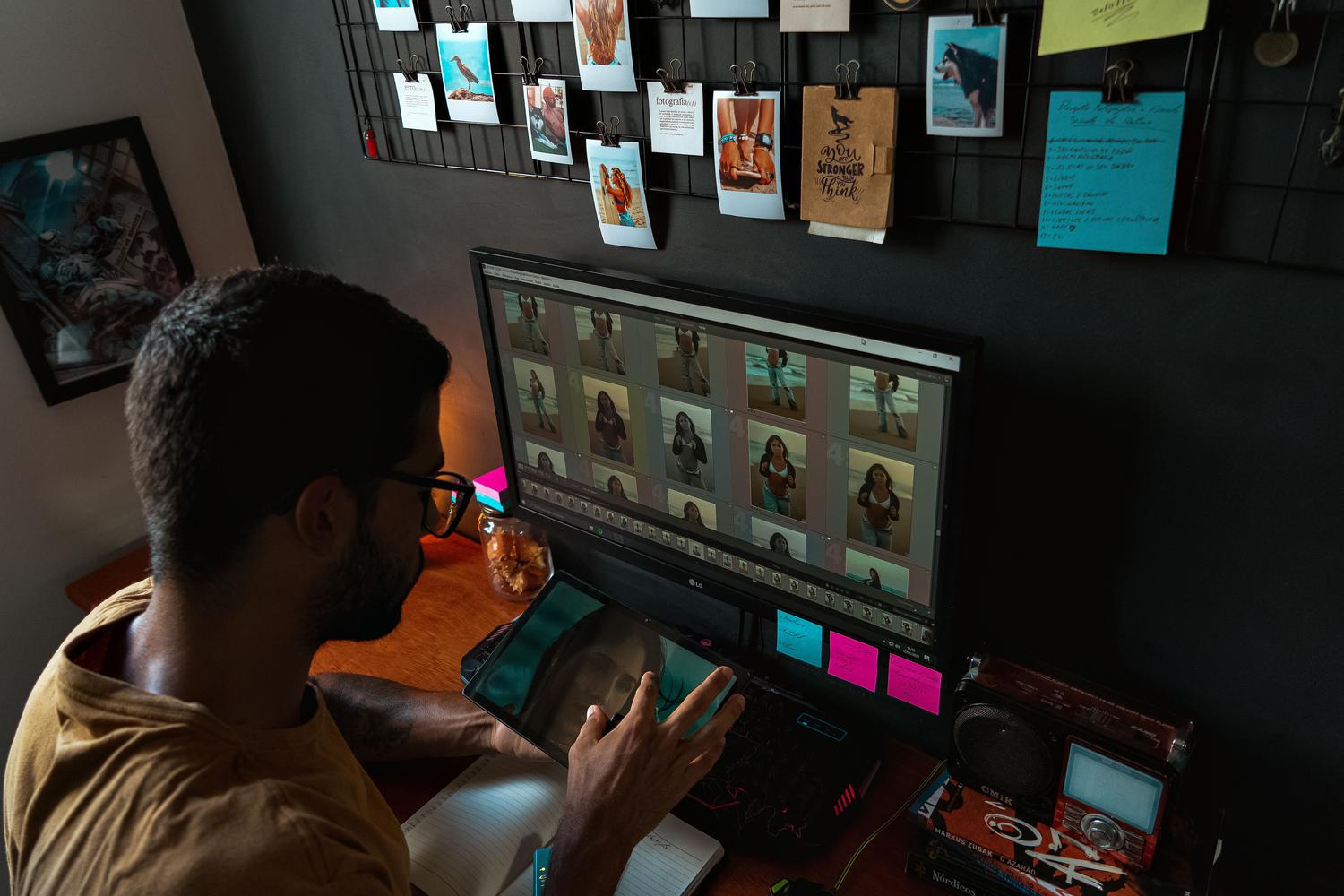 Persona editando fotografías en un ordenador, destacando la importancia del revelado digital en el flujo de trabajo RAW.