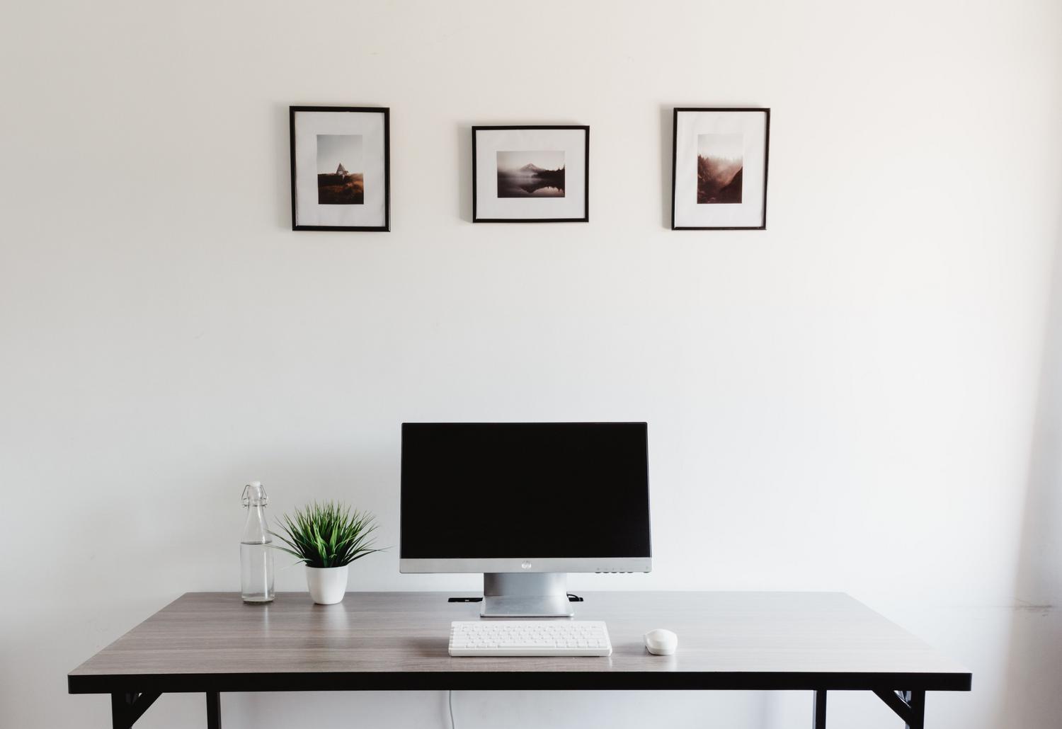 Escritorio de oficina minimalista y ergonómico con ordenador, teclado y ratón, ideal para maximizar la productividad profesional.