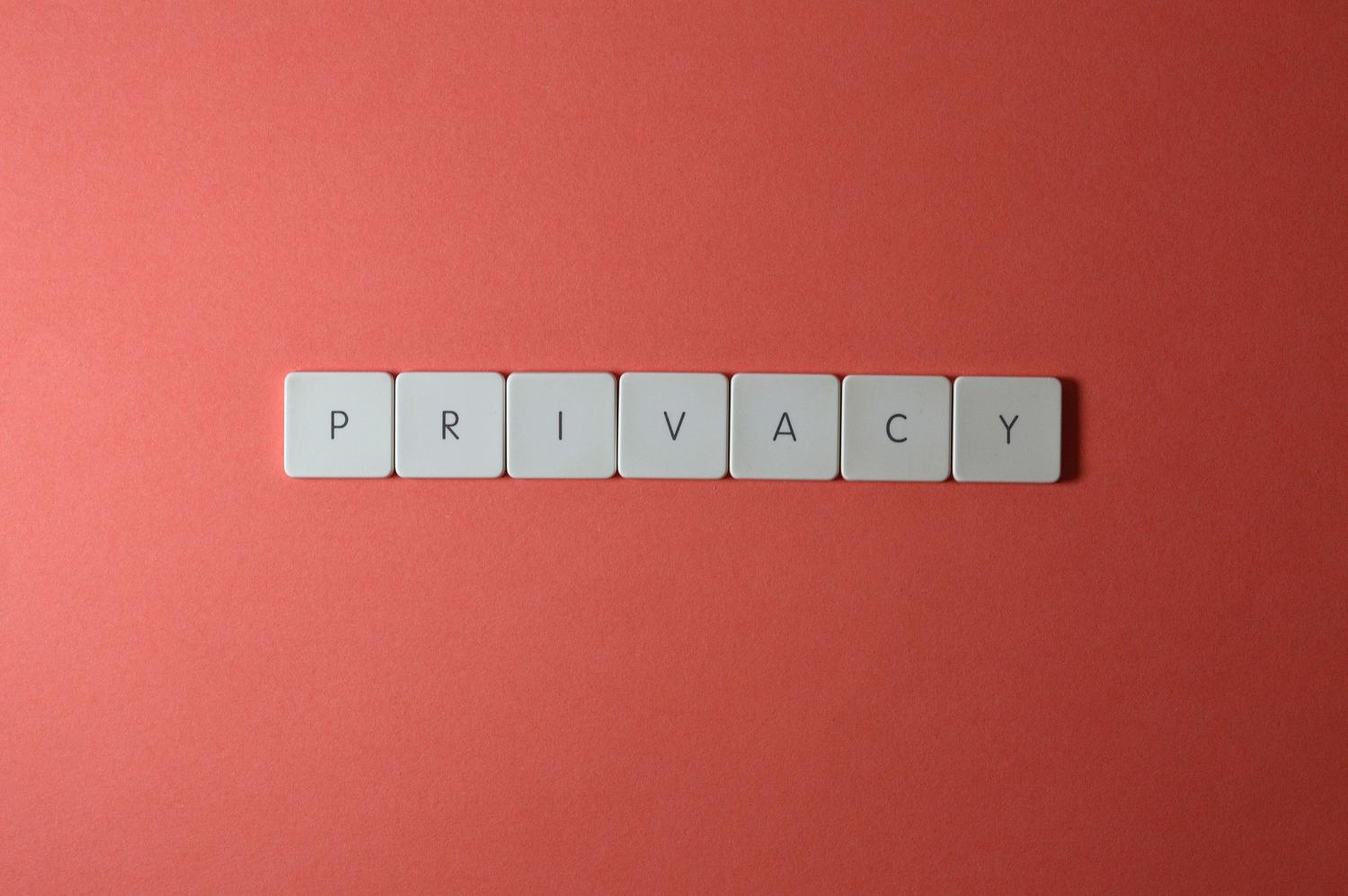 Primer plano de letras formando la palabra PRIVACY sobre un fondo rojo, representando la protección de datos personales.