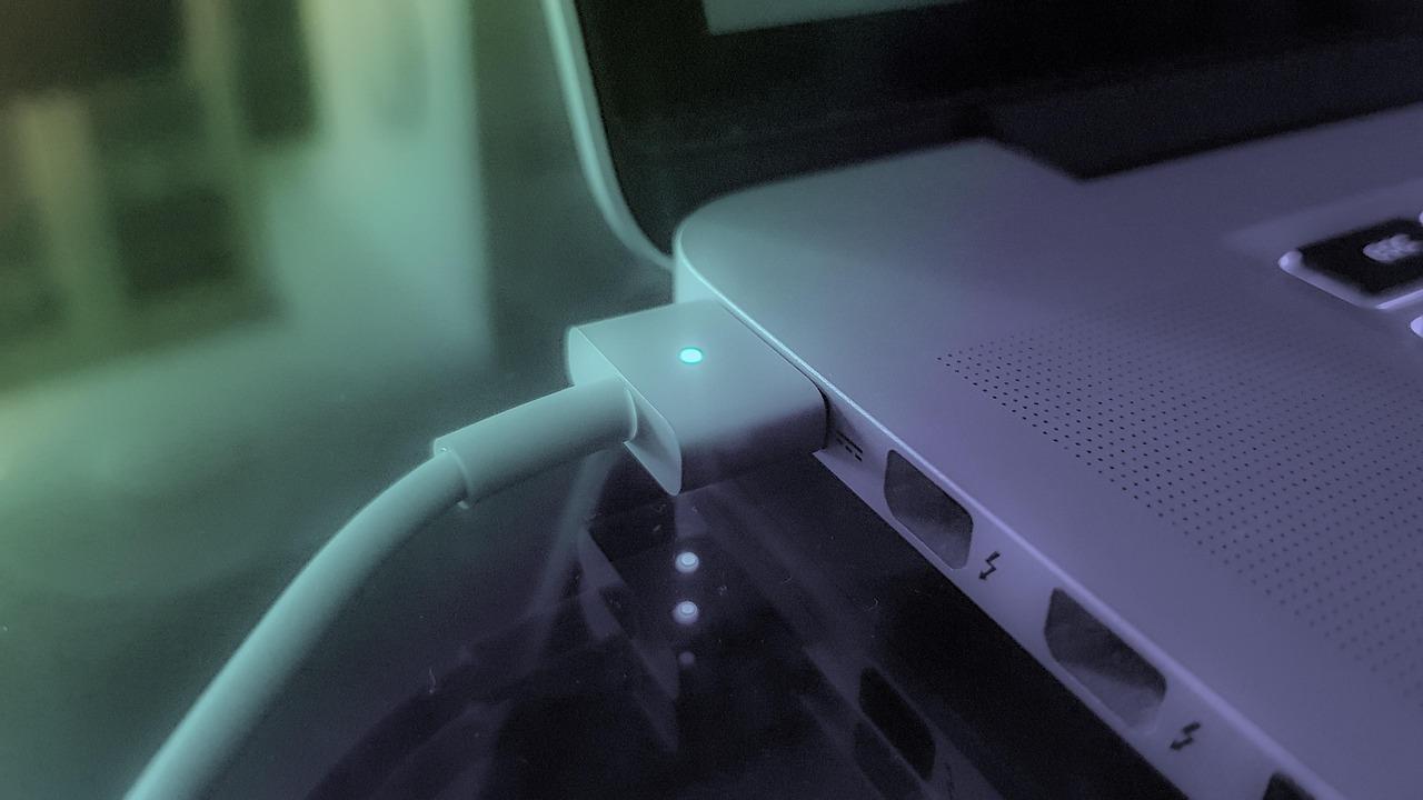Cable de carga conectado a una laptop, ilustrando la correcta gestión de la batería para prolongar su vida útil.