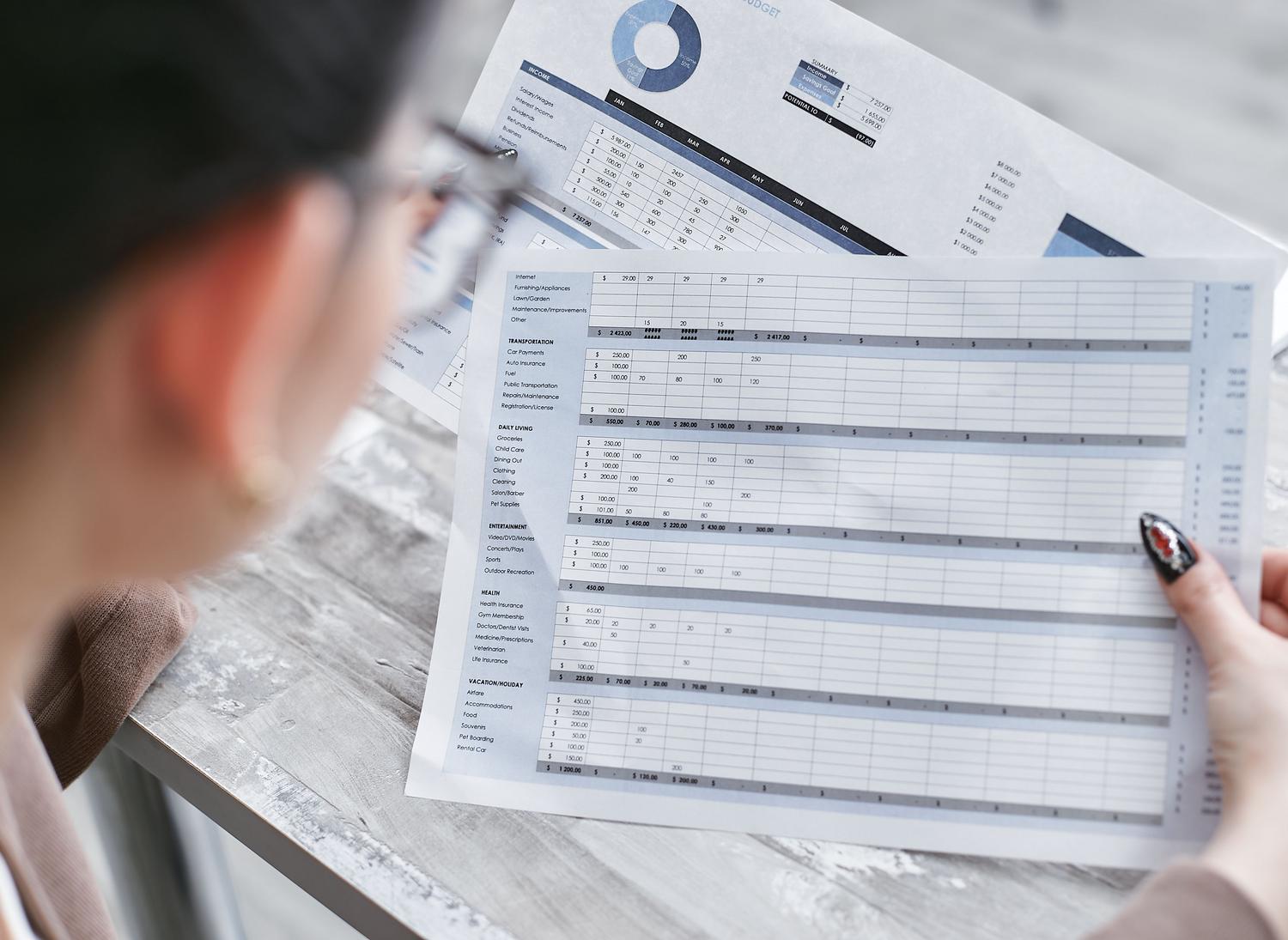 Profesional revisando hojas de cálculo impresas para el análisis de datos